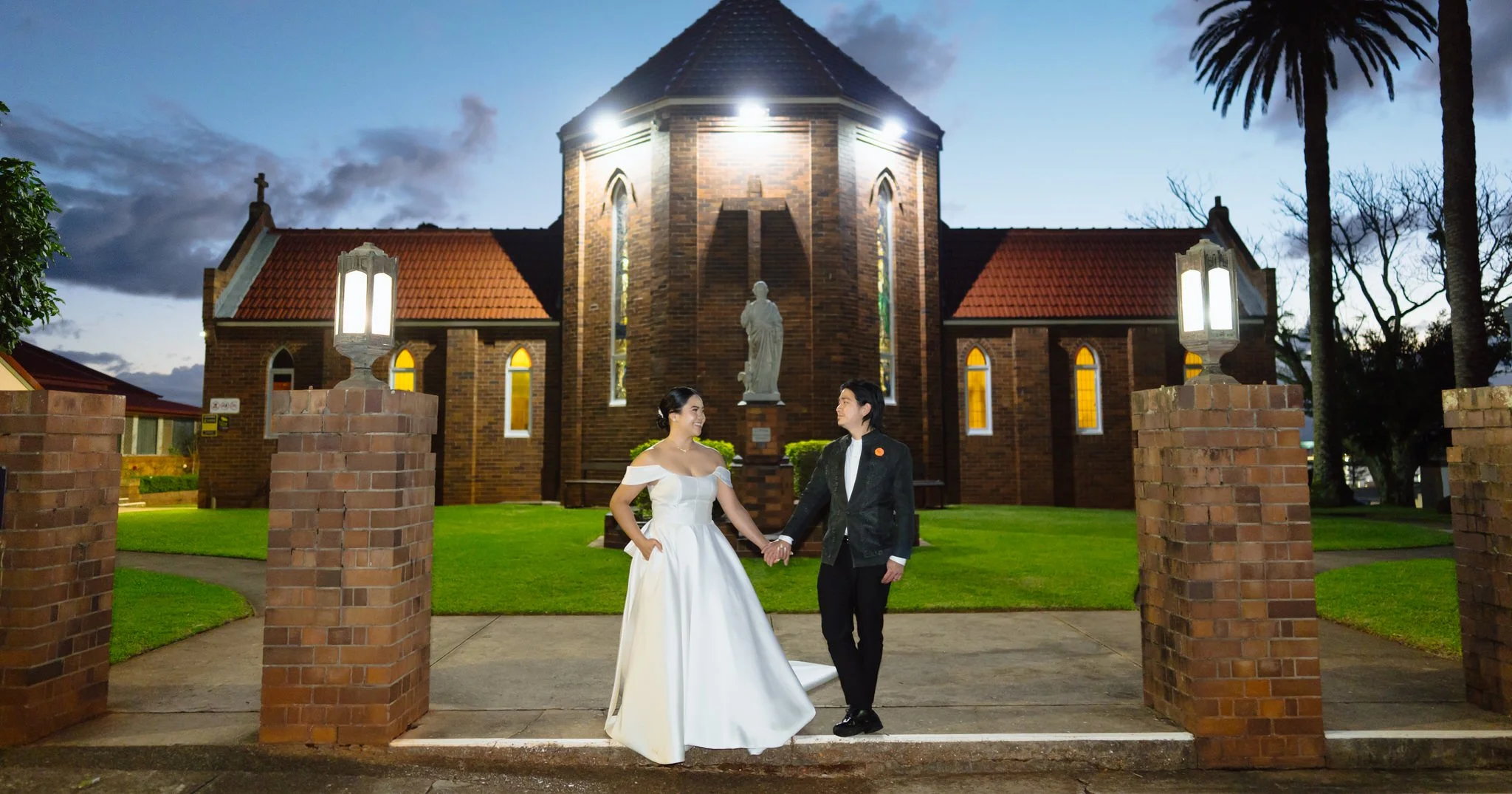 Bride and groom outside St Agnes' Catholic Parish Port Macquarie during evening wedding portraits