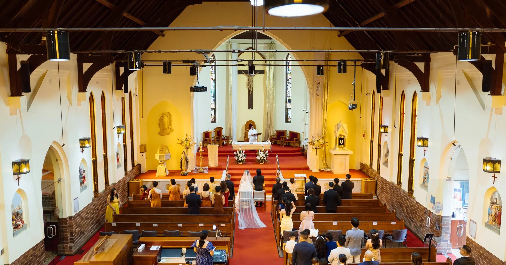 Wedding ceremony inside St Agnes' Catholic Parish Port Macquarie with guests gathered during the service