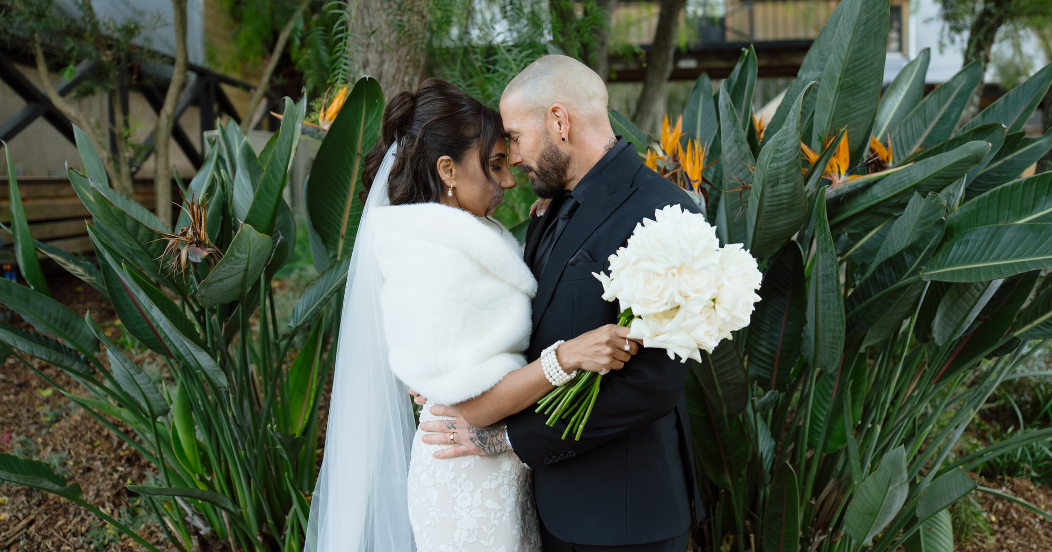 Bride and groom embracing among gardens at Peppers Creek in winter