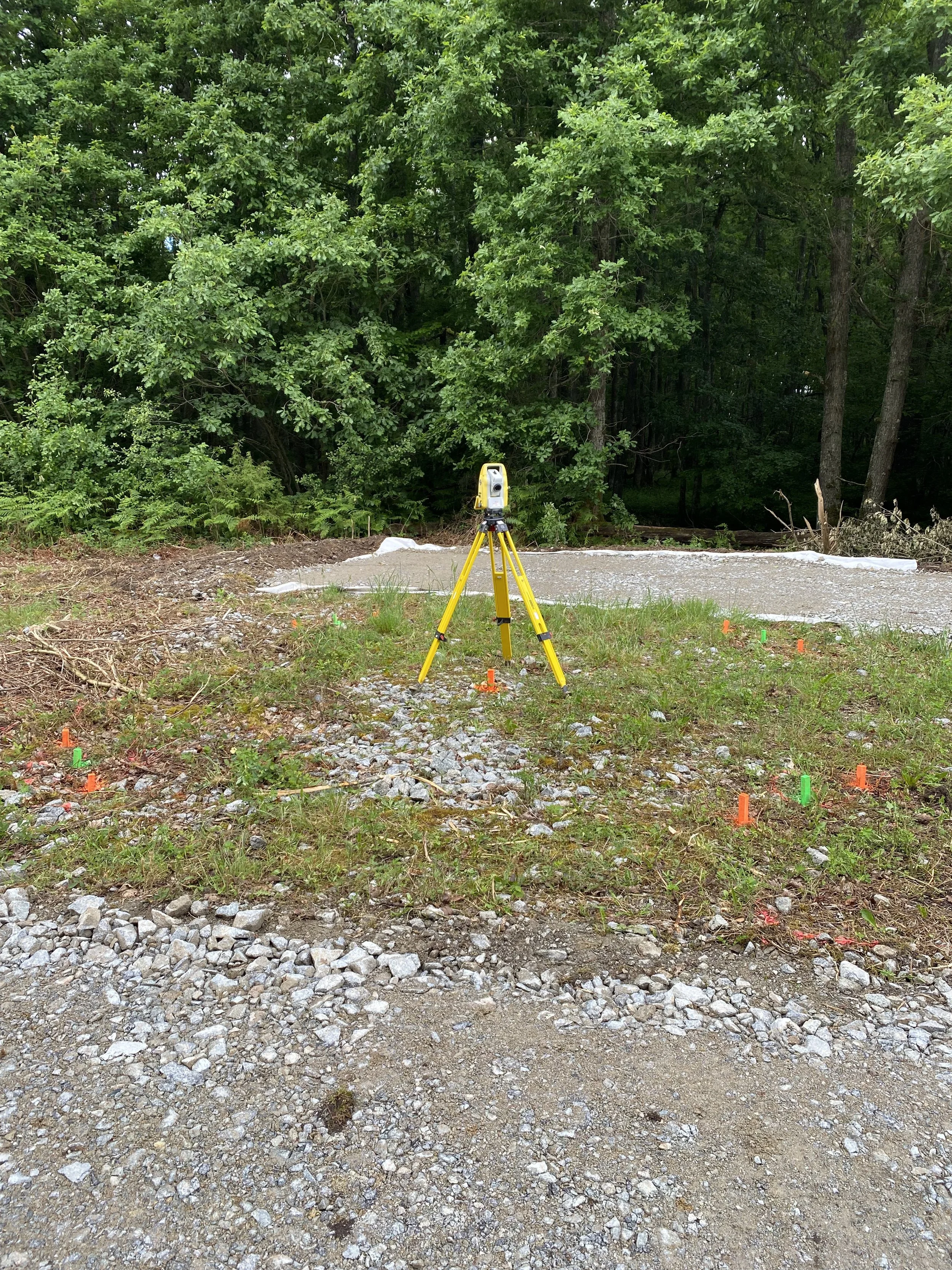 Outil de levé topographique avec trépied orange sur un site en plein air, avec un fond de forêt dense.
Lebon Services - votre prestataire pour vos chantiers de lignes électriques haute tension.