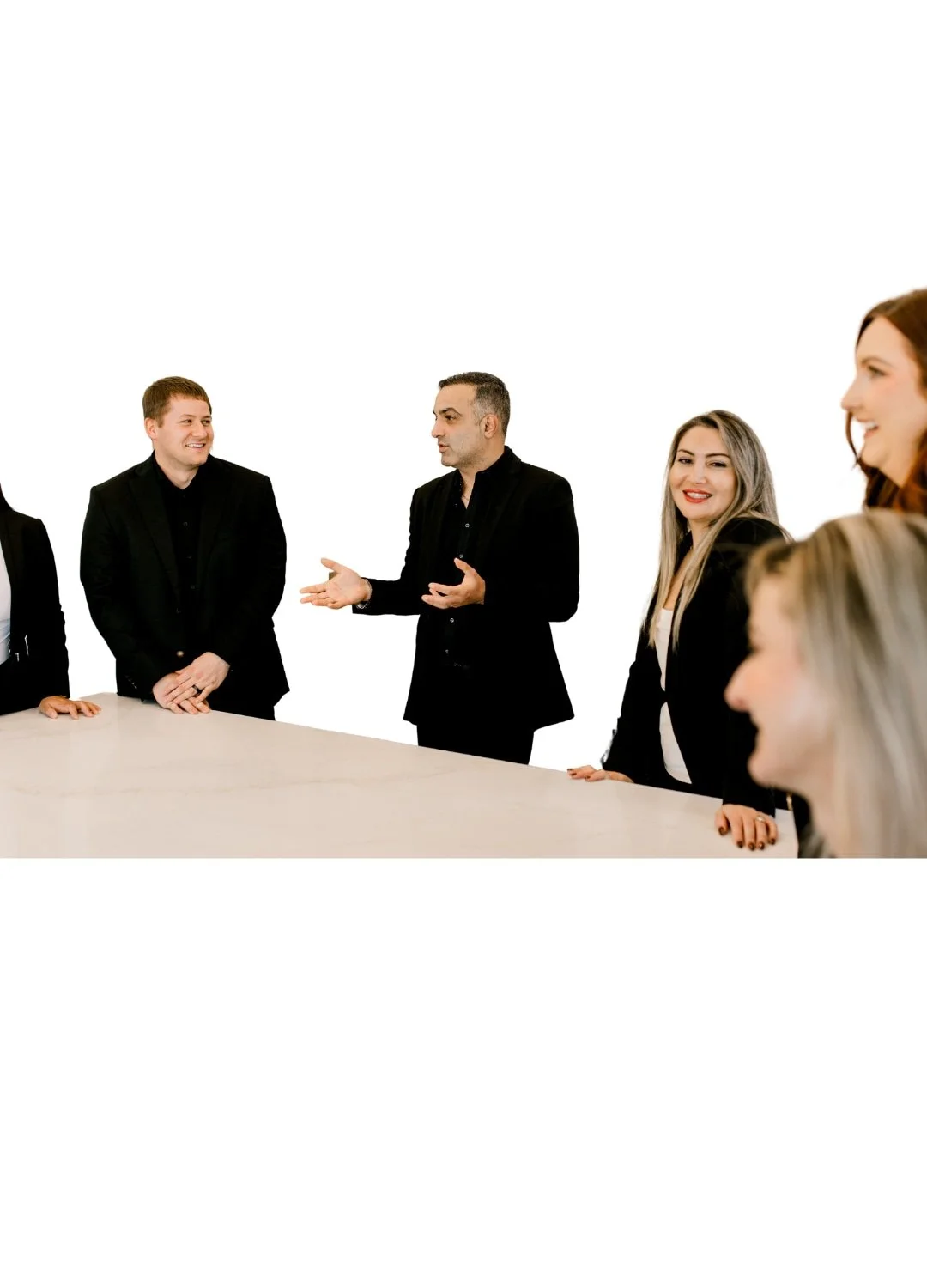 Group of diverse professionals in formal attire having a discussion in a meeting room.