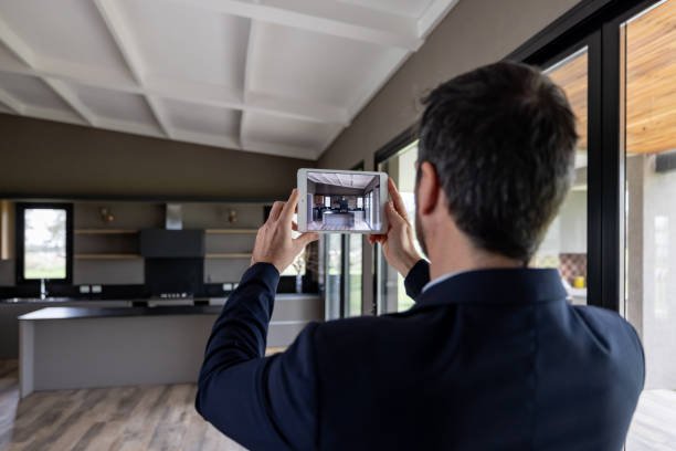 Real estate agent taking a virtual home tour photo with a tablet inside a modern kitchen in Dallas TX
