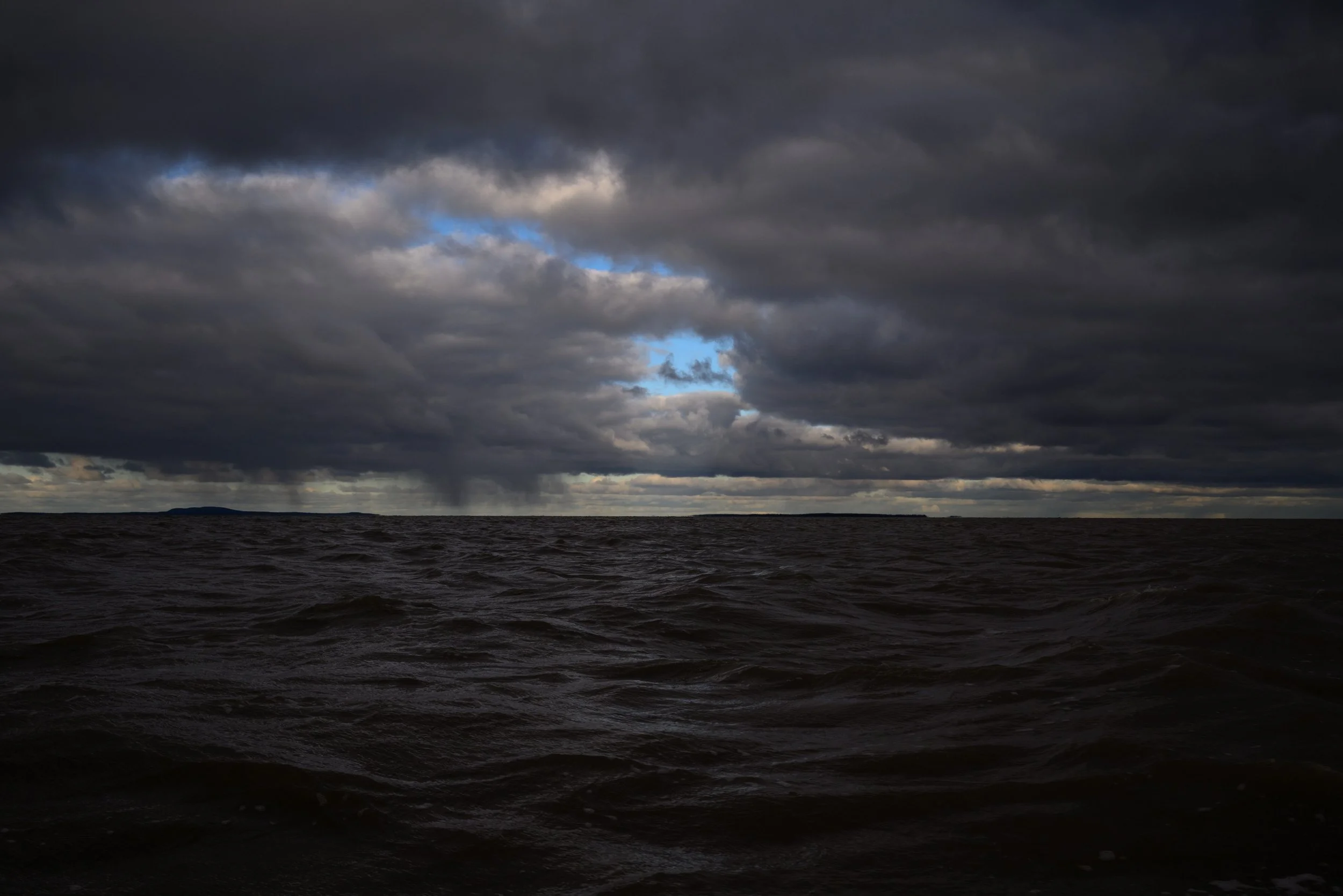 Blue skies breaking through over the stormy waters of James Bay.