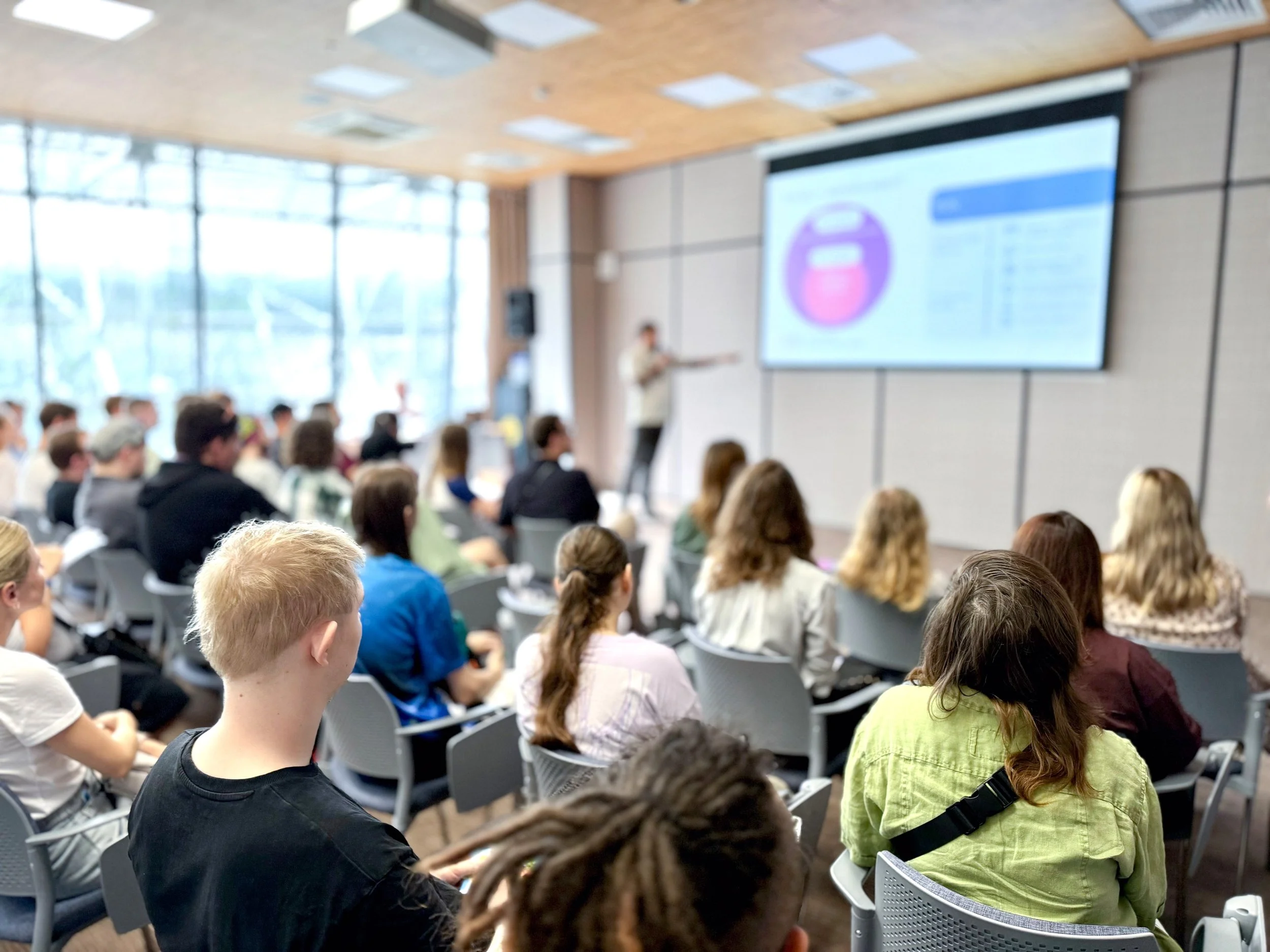 Crowd of people attending a live workshop on dementia care skills training with the facilitator sharing key insights on brain change, and dementia behaviours