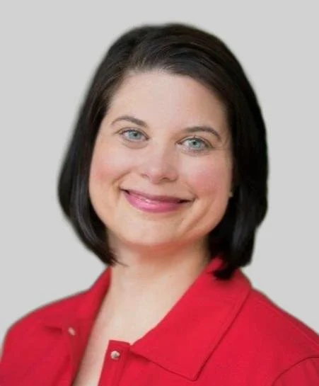 Portrait of a woman with short dark hair, blue eyes, smiling, wearing a red shirt, against a gray background. who is the founder of careknowhow.com