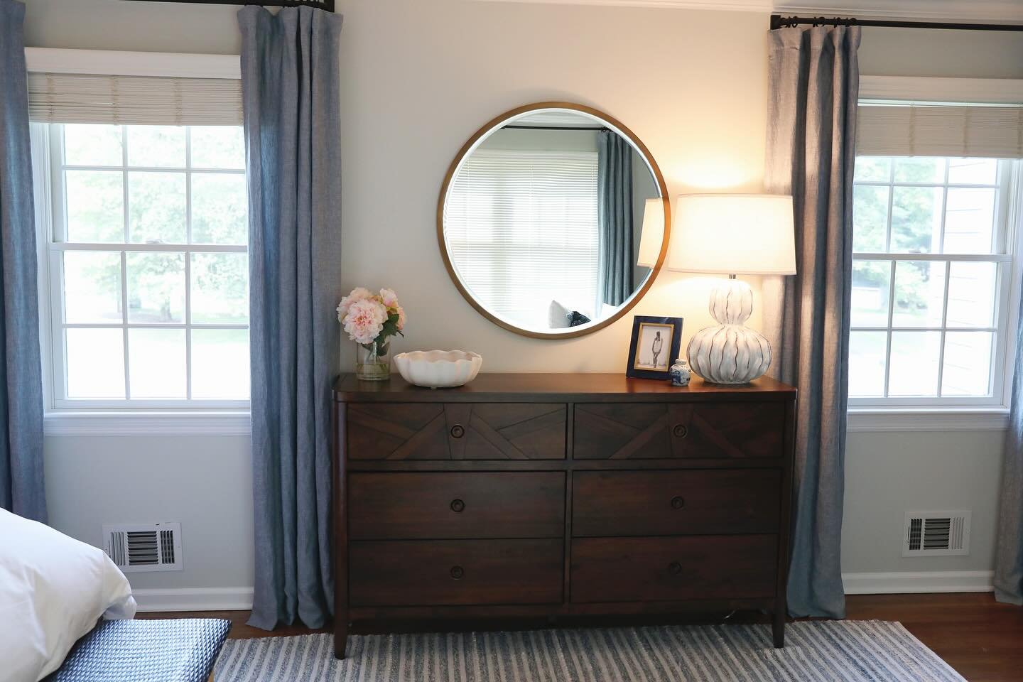 This client hired us to give the primary bedroom a facelift. They did not want to paint or get new case goods but they wanted to love waking up in this space everyday. We introduced soft shades of blue, purcahsed a larger rug, changed the window trea