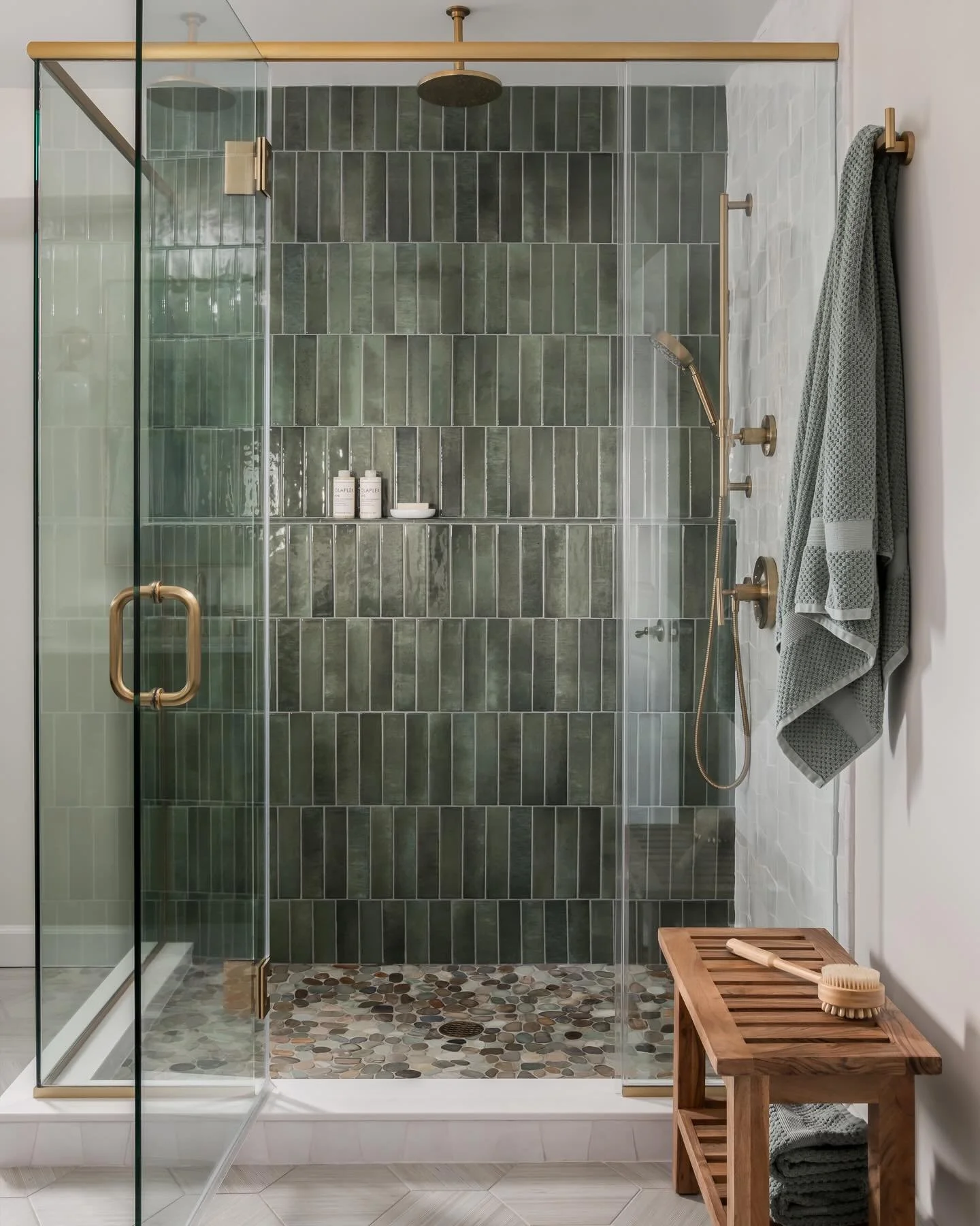 This shower is everything. The moody green tile paired with the handmade trapezoid zellige, the river rock floor and the warm brass details feels so calm and elevated, but still timeless. One of those bathrooms you never want to leave. 
Design- Kerry