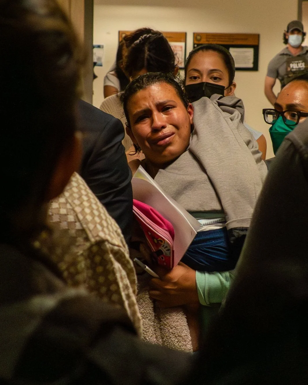 A woman sobs, clutching her baby, moments after her older son is taken by ICE. Her cries cut through the hallway.