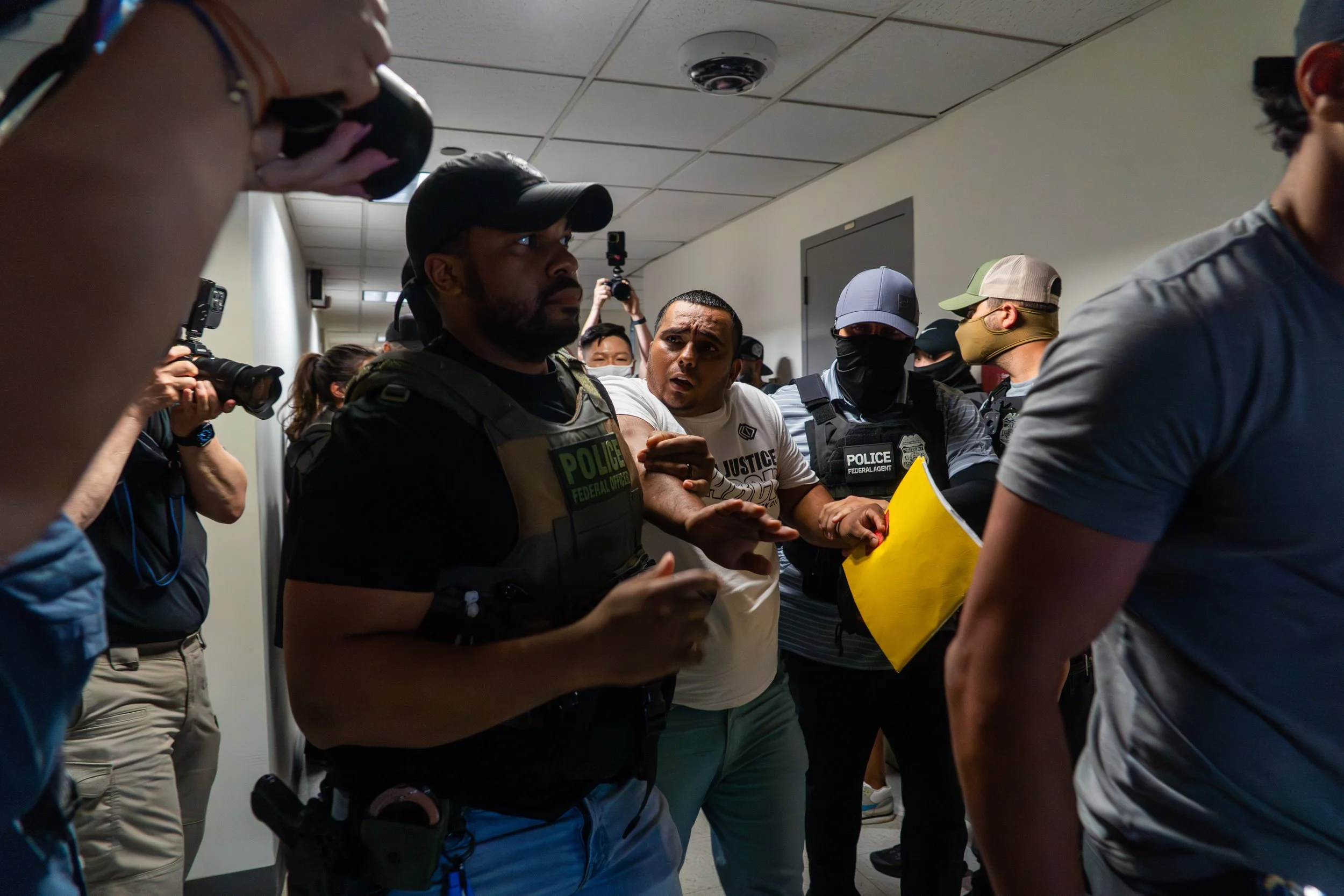 A man looks scared and disoriented as ICE detains him in the hallway outside immigration court as he's quickly ushered to the stairwell.