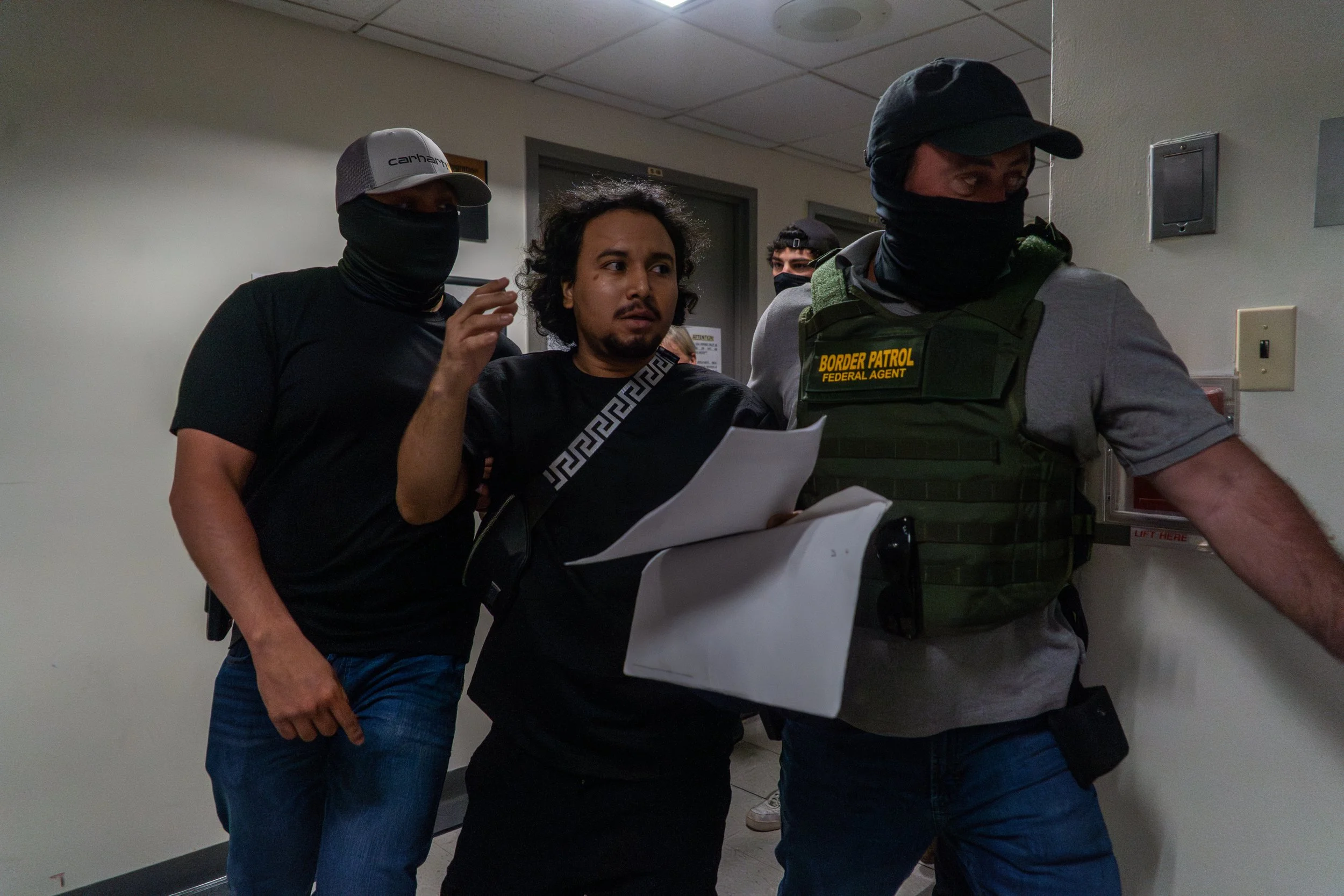 He clutched court papers in his hands as two Border Patrol agents flanked him and lead him toward the stairway.