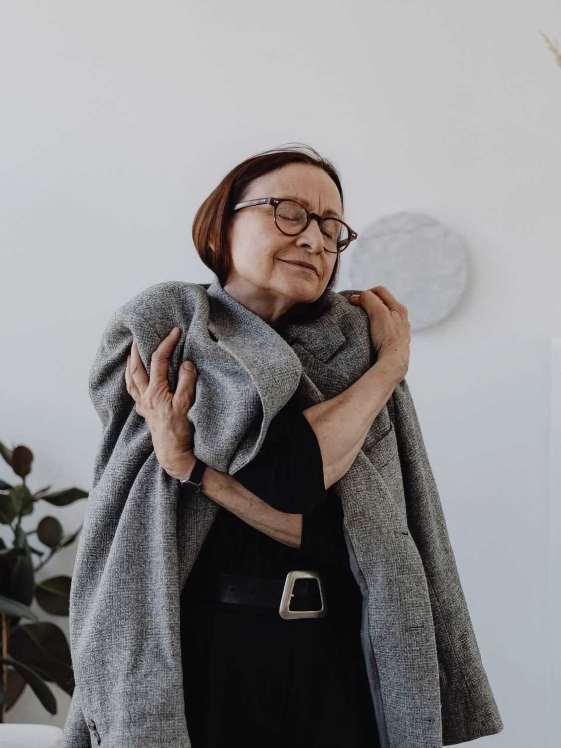 Older woman hugging herself after emotion focused therapy