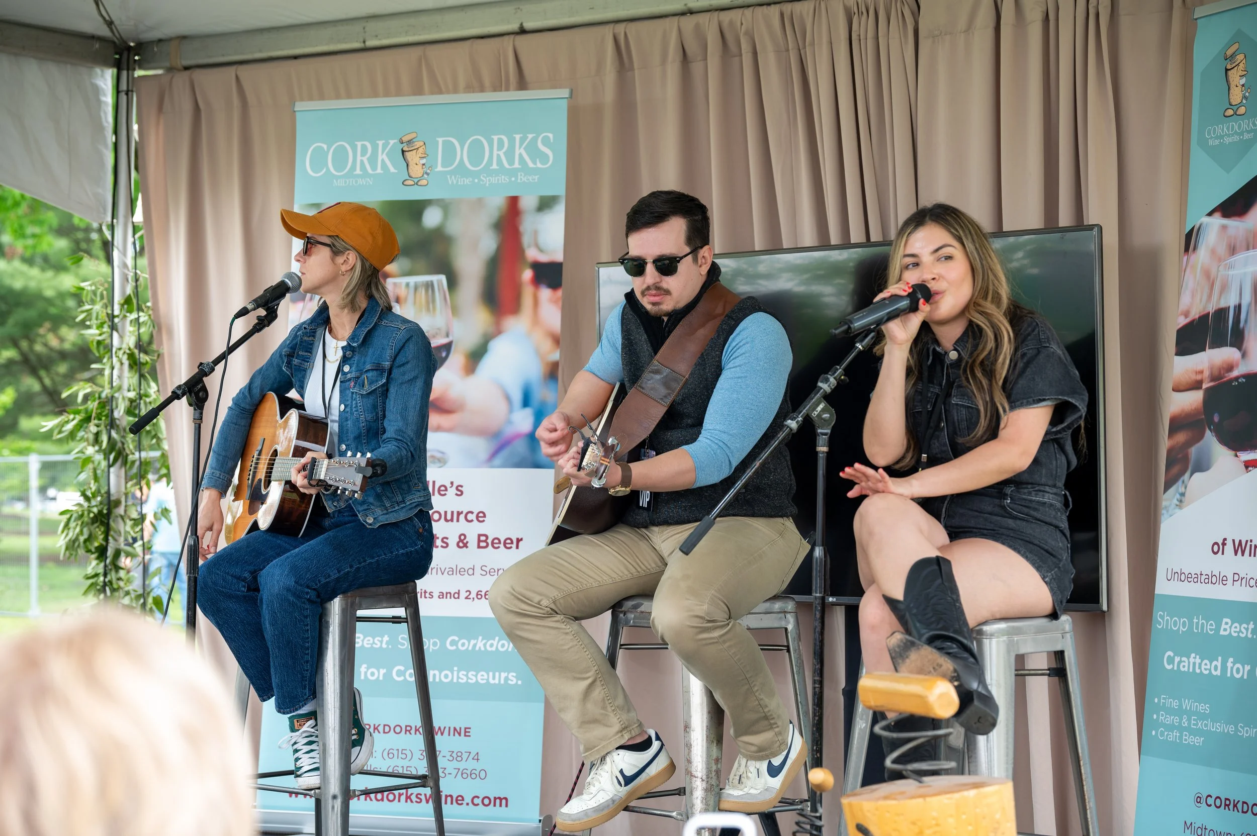 Cookbook titled 'Baked Nashville' with a picture of a slice of cake on a blue plate on the cover, placed on a wooden table along with baking utensils and ingredients.