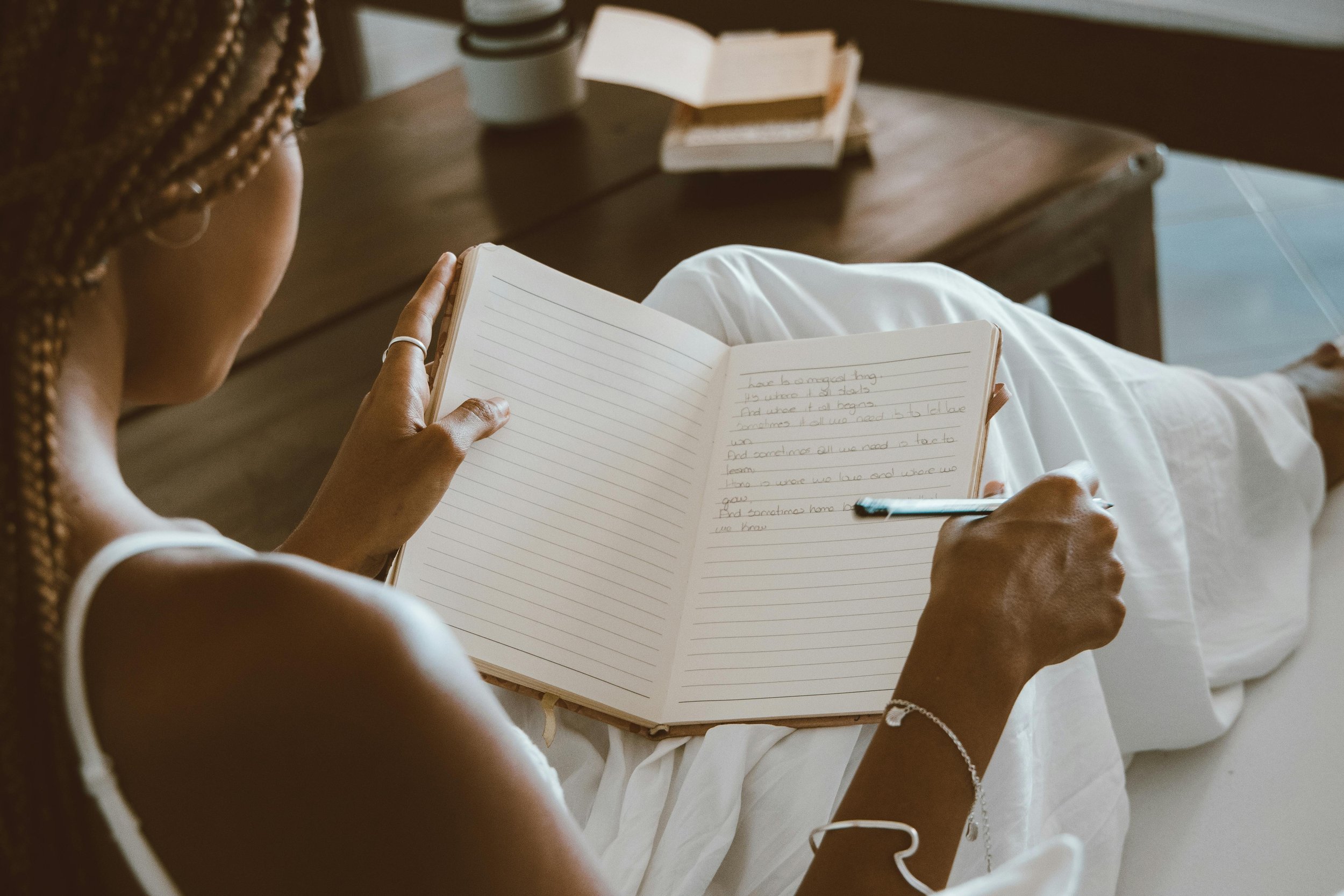 woman sitting on couch and journaling