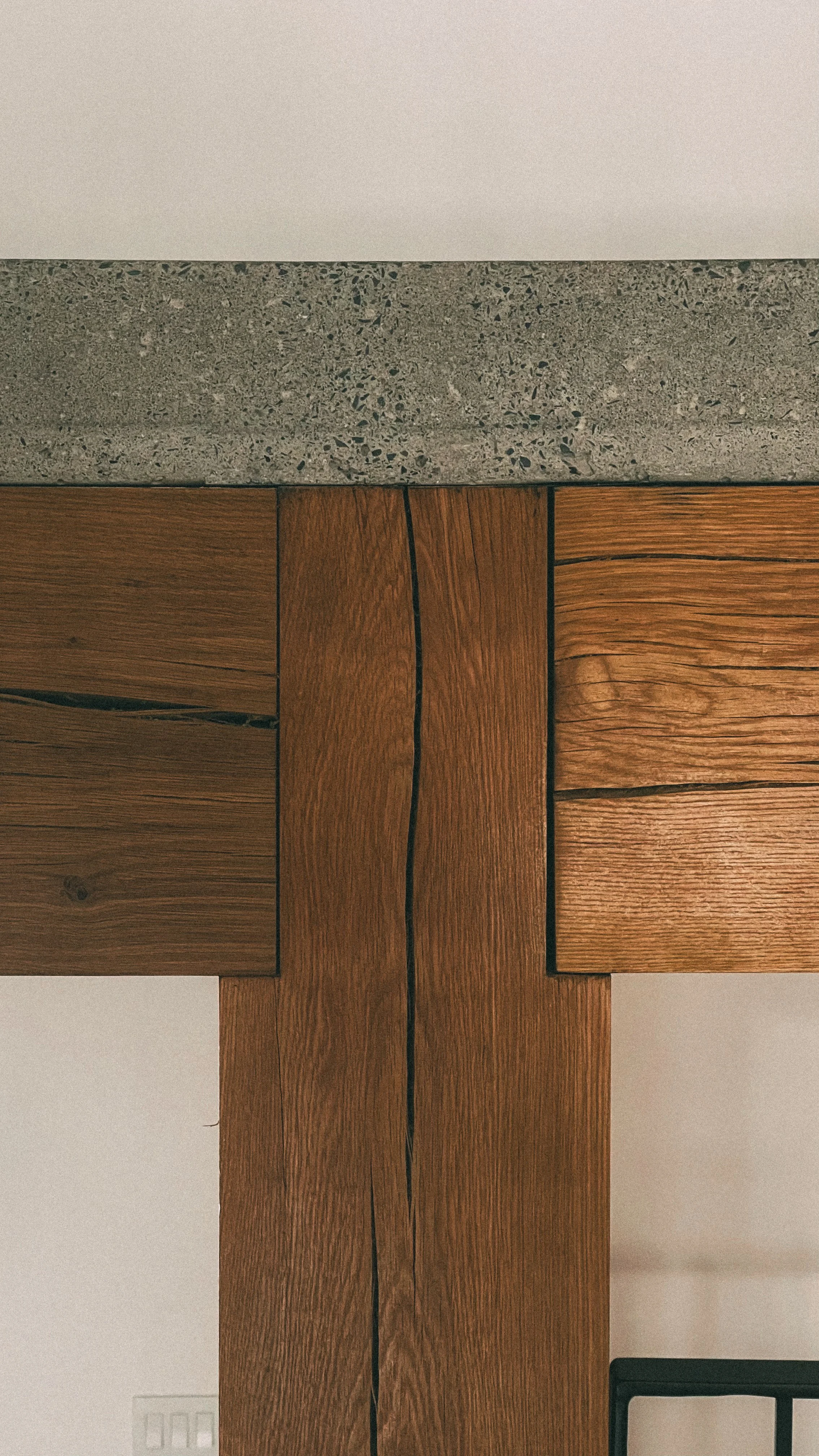 Un carrelage en pierre au-dessus d'une structure en bois avec des joints noirs.