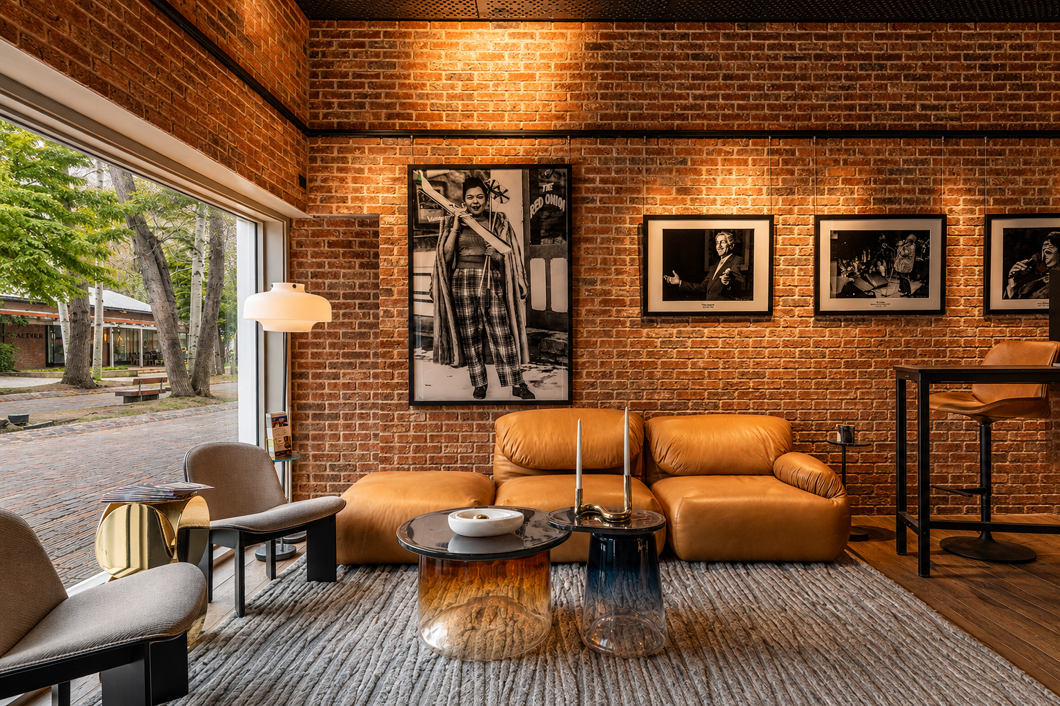 Lounge seating area at the Paul JAS Center with framed archival music photography on brick Caption: Lounge and gallery seating area inside the Paul JAS Center, with framed black-and-white archival photography of past Jazz Aspen Snowmass performers di