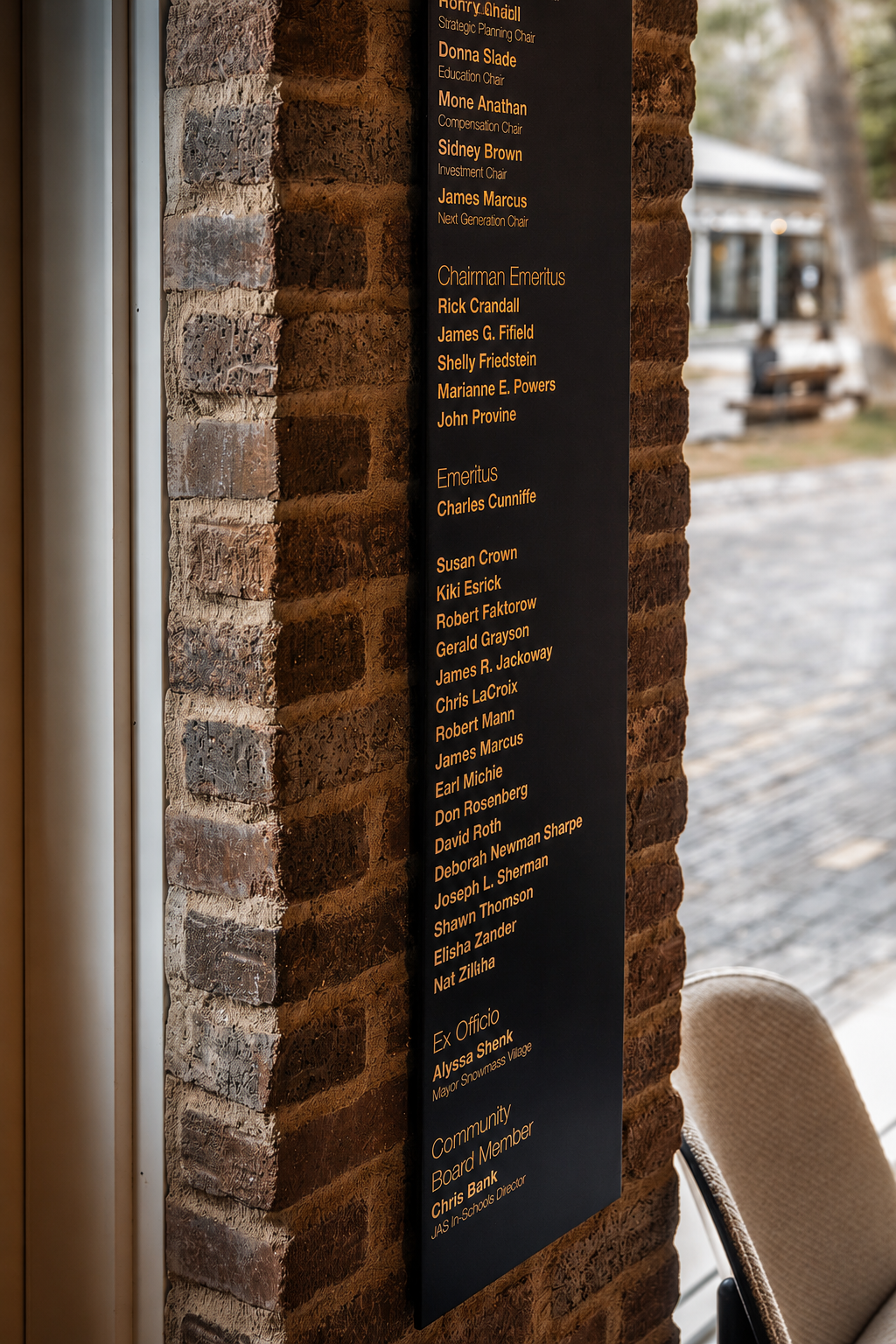 Detail of the Board of Directors donor wall listing on brick at the Paul JAS Center Caption: Continued detail of the Paul JAS Center's etched Board of Directors donor wall, listing chairman emeritus, emeritus, and community board members on exposed b