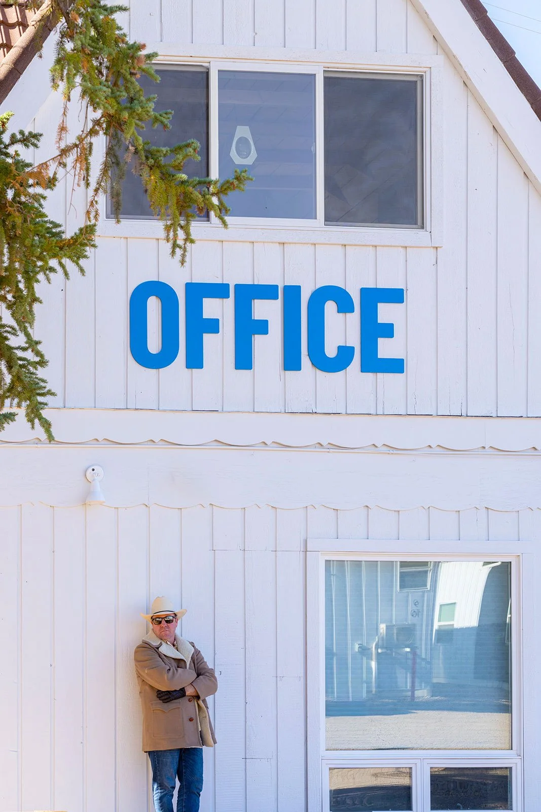 Team member outside the Tiny Town office beneath the blue "Office" sign

A Tiny Town team member stands outside the leasing office, underscoring the community's approachable, western-inspired character.