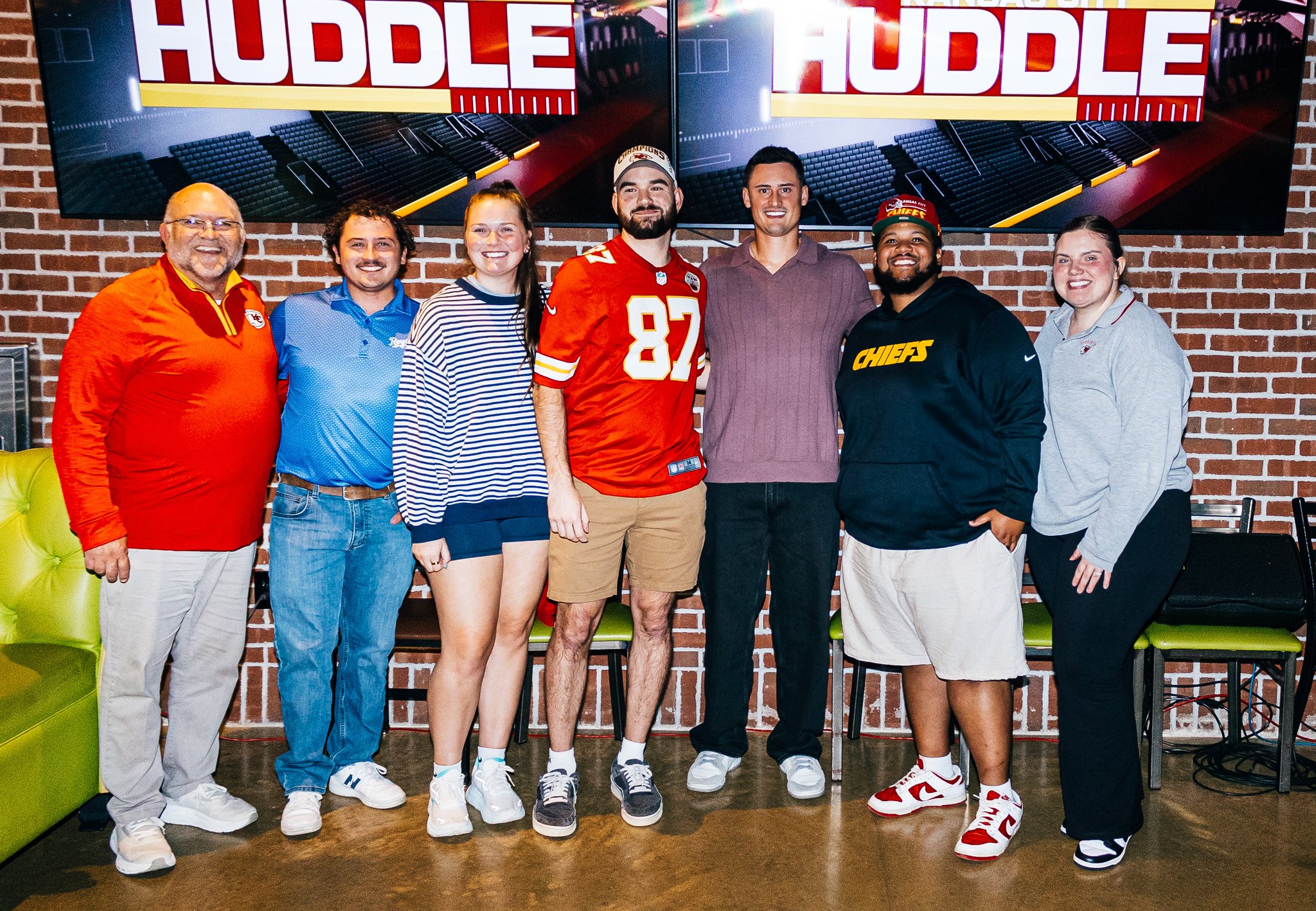 Matt Araiza posing for a picture with a group of fans during the live taping of Kansas City Huddle