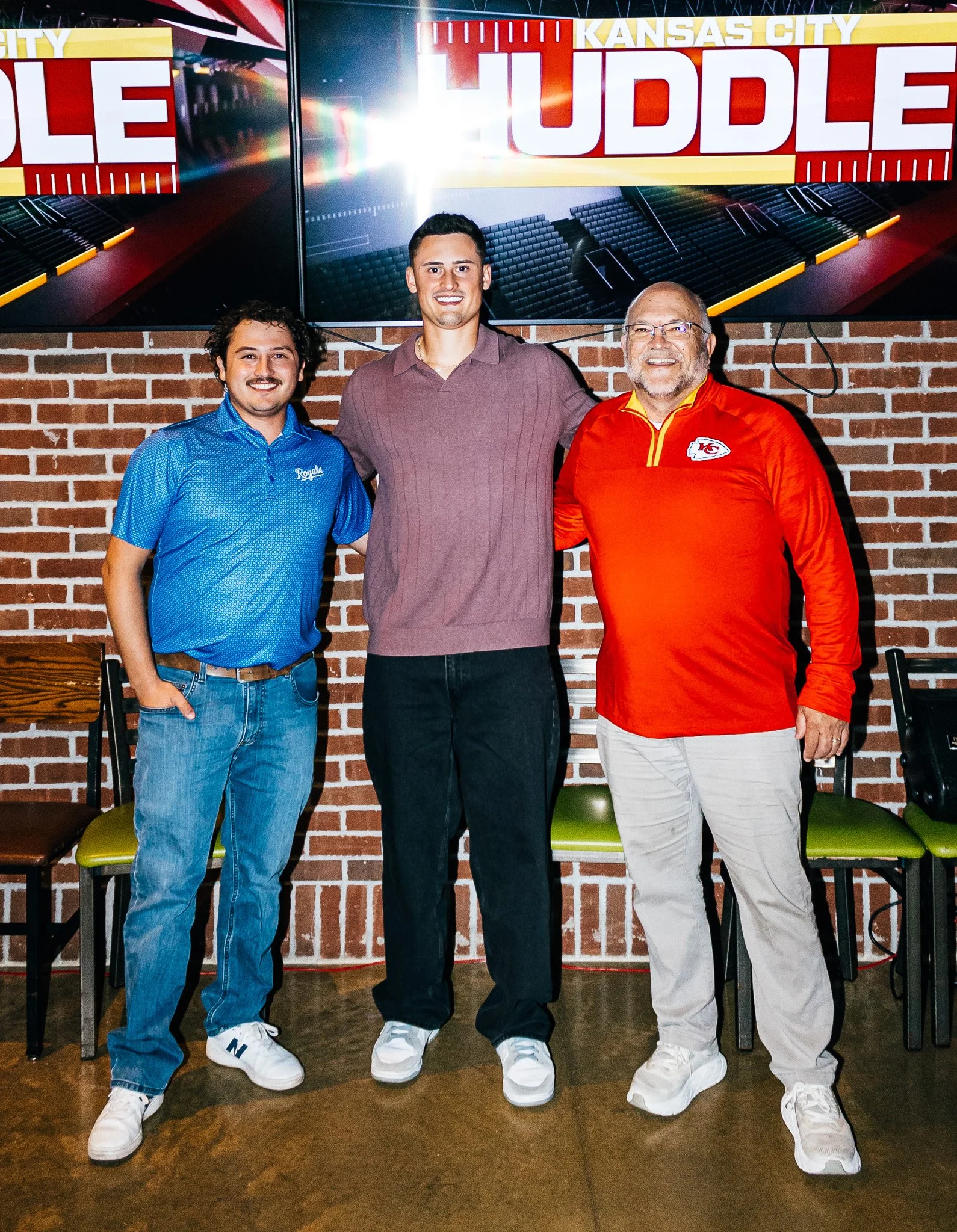 Matt Araiza posing for a picture with two fans at Chicken N Pickle Overland Park during Kansas City Huddle