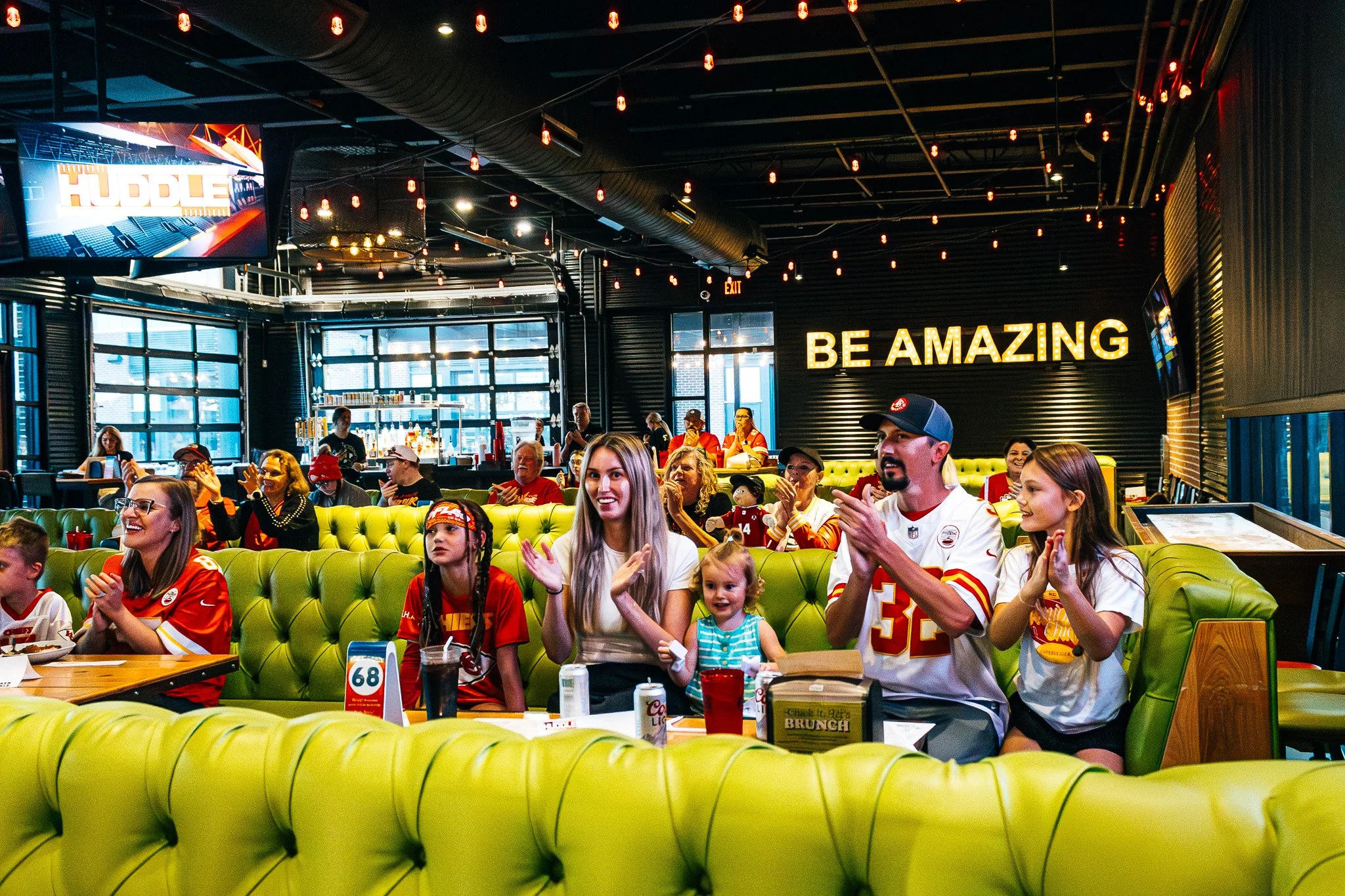 Fans clapping during the Kansas City Huddle live taping at Chicken N Pickle in Overland Park