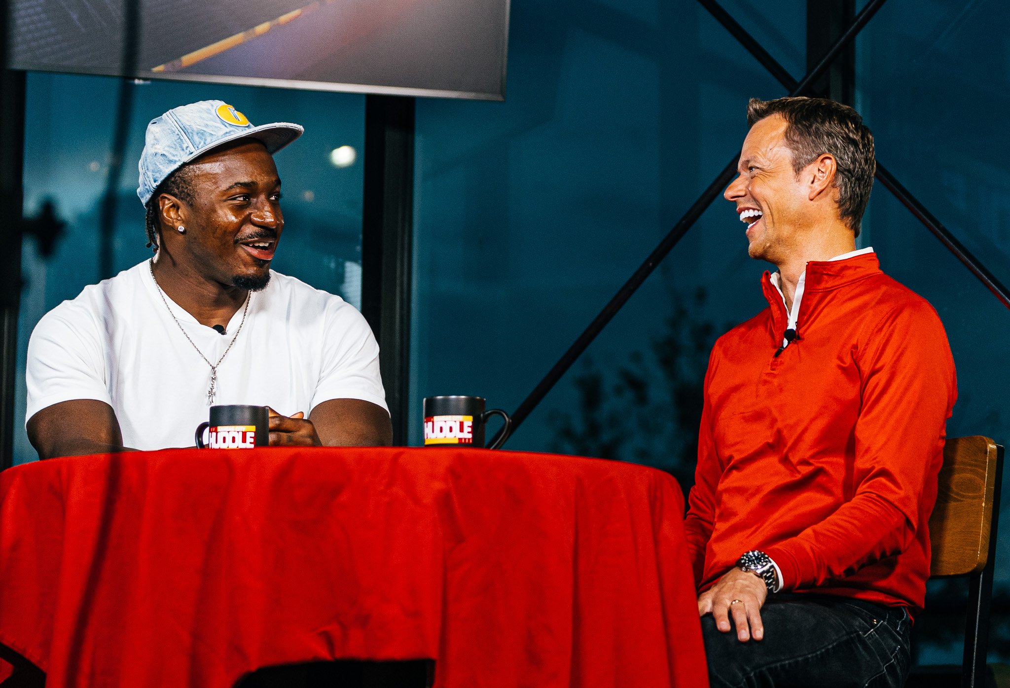 Jeffrey Bassa and Rob Collins laughing during a live Kansas City Huddle episode