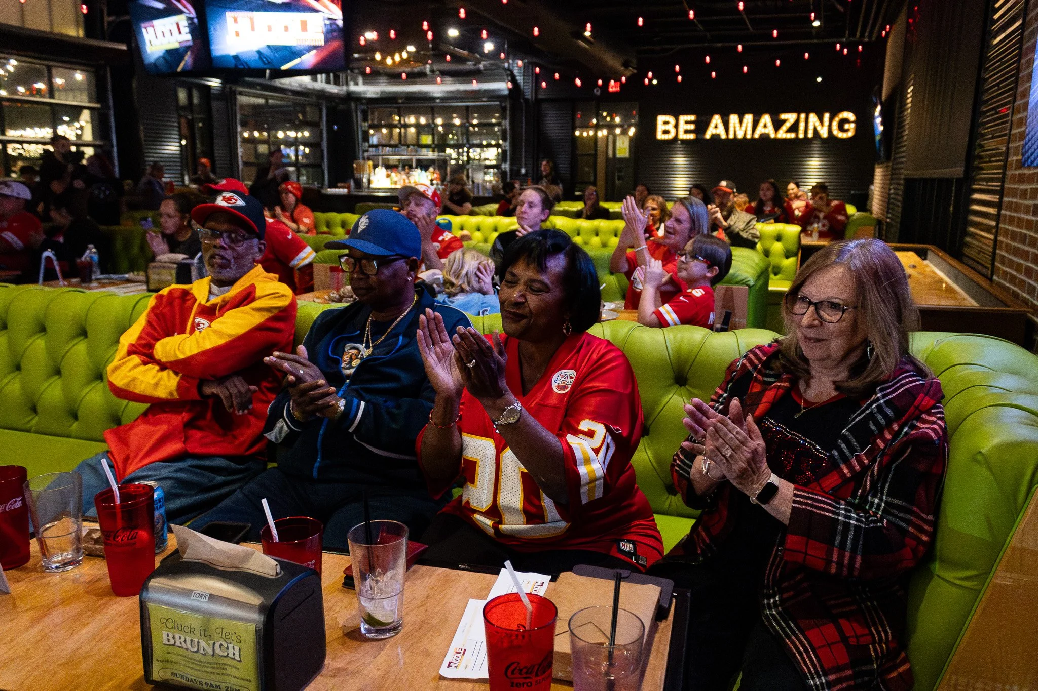 Football fans gather at Chicken N Pickle to watch Kansas City Huddle live.
