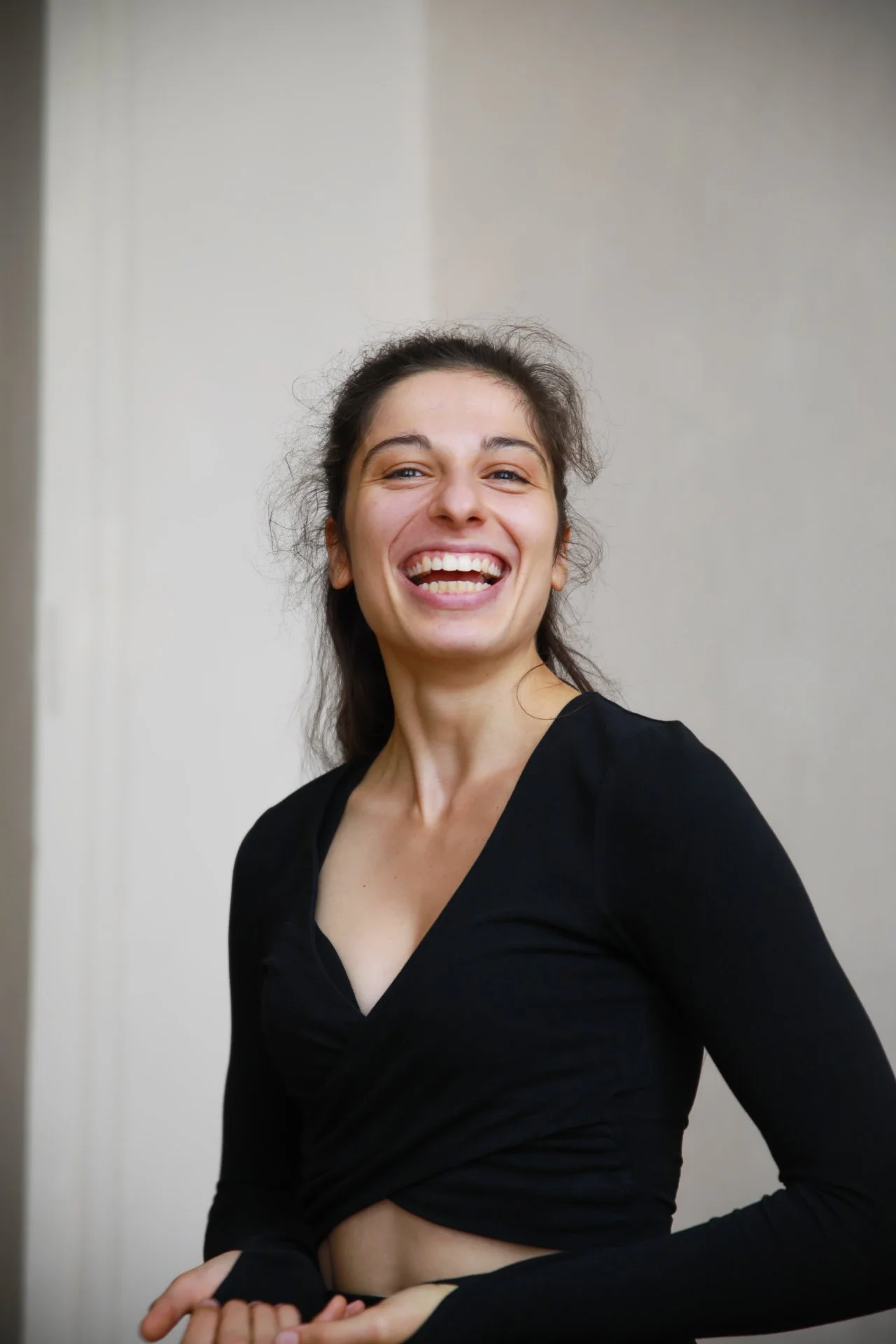 Une femme souriante portant un haut noir