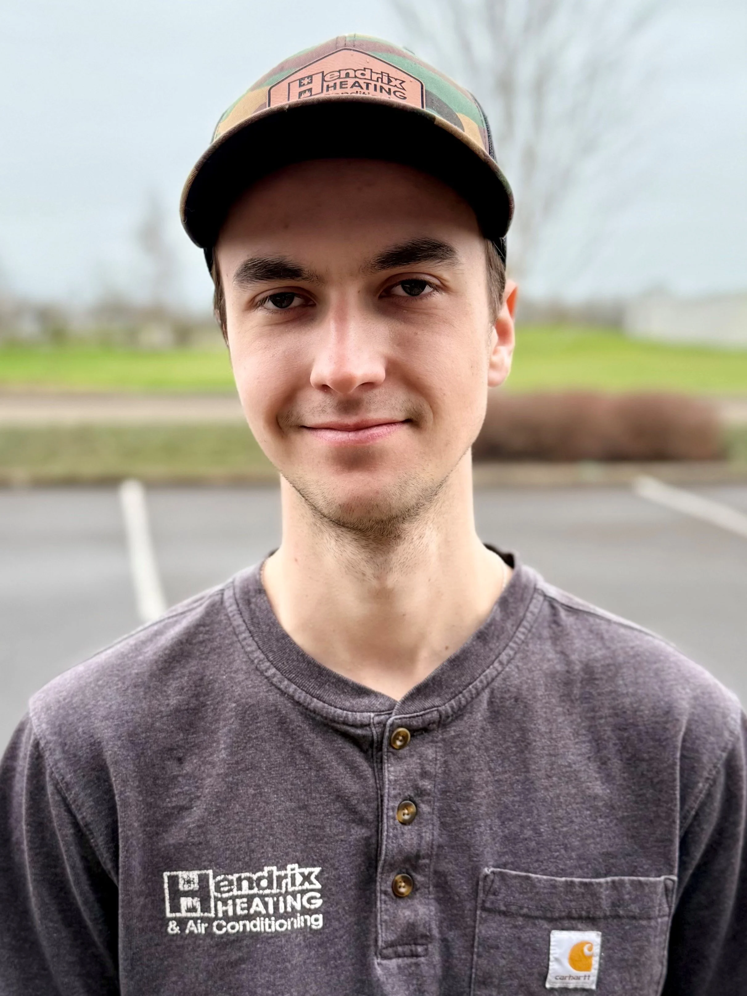 Man wearing Hendrix Heating & Air Conditioning shirt and cap outdoors