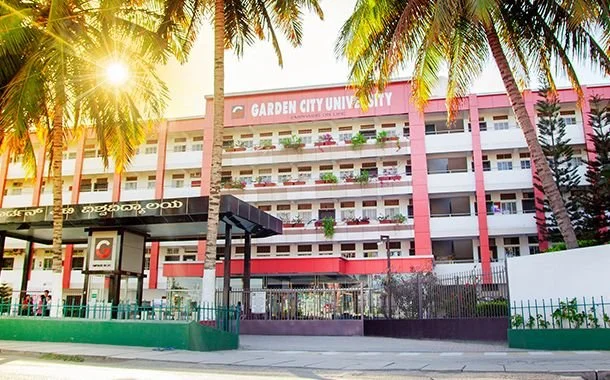 GARDEN CITY UNIVERSITY building with palm trees and sunlight.