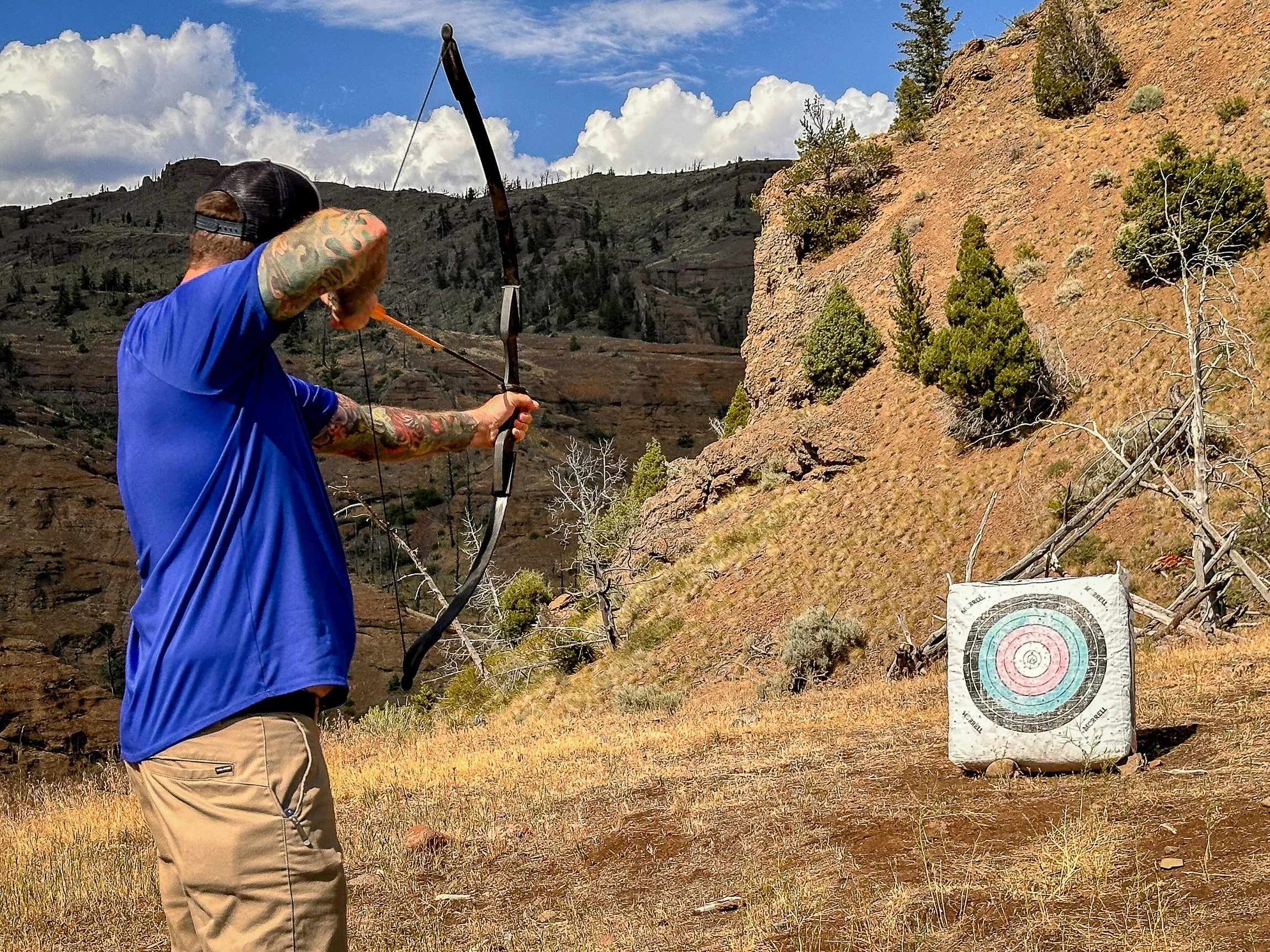 A dude ranch guest aims at a target during archery practice. 