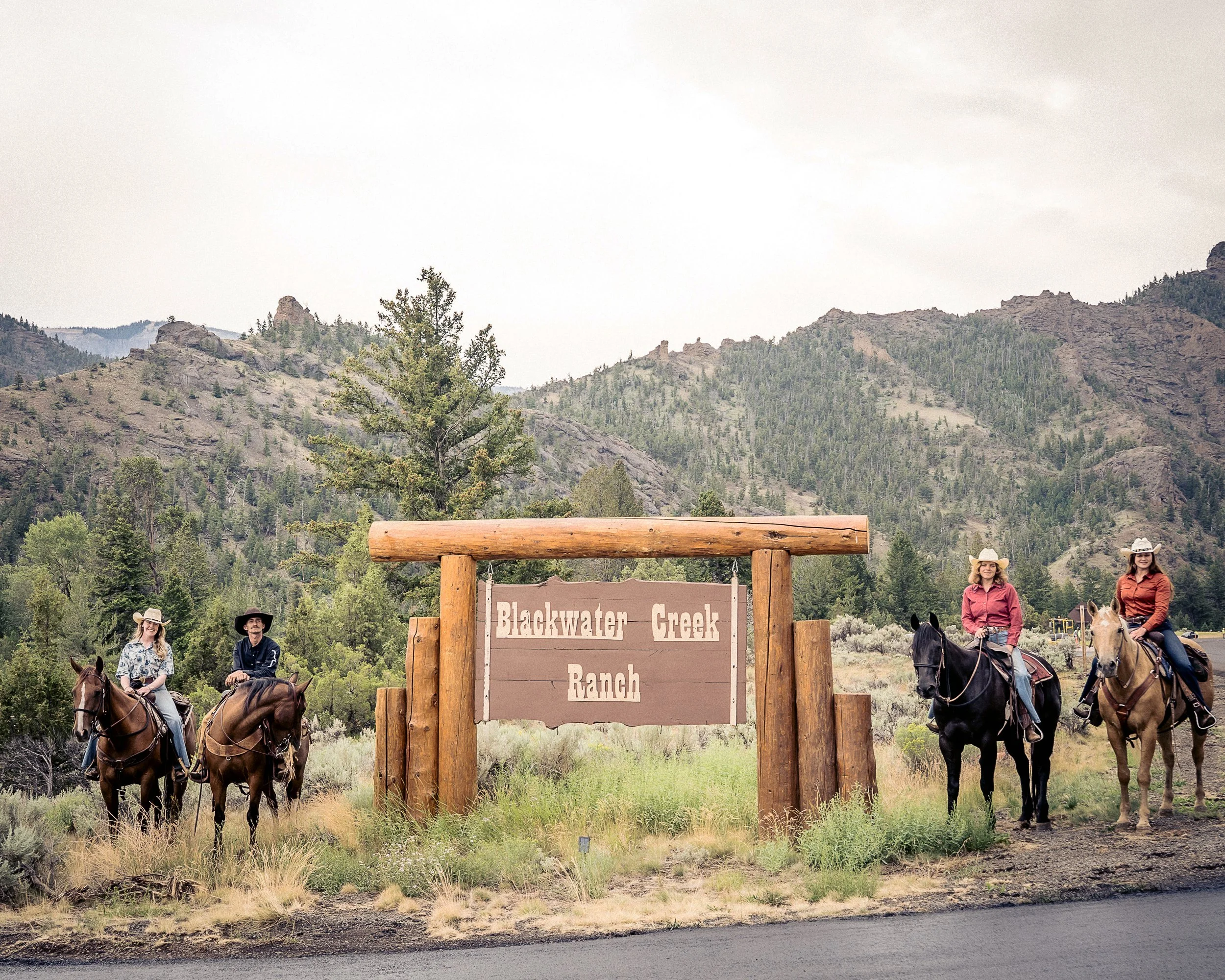 Staff at Blackwater Creek Ranch pose with the ranch sign.