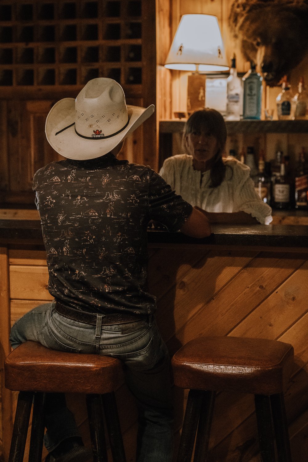 A guest and bartender in the bar at Blackwater Creek Ranch.