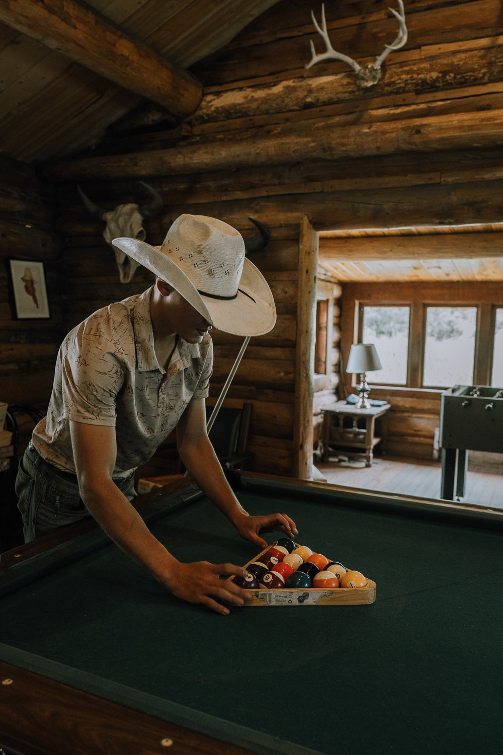 A dude ranch guest racks a pool table at Blackwater Creek Ranch.
