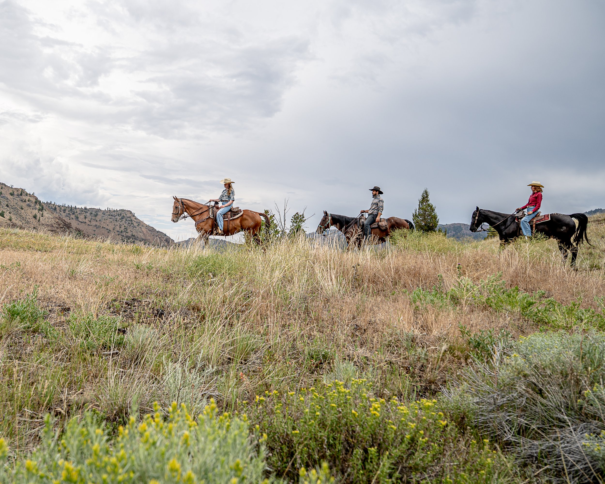 Horseback riders cross a ridge on a Wyoming dude ranch vacation.