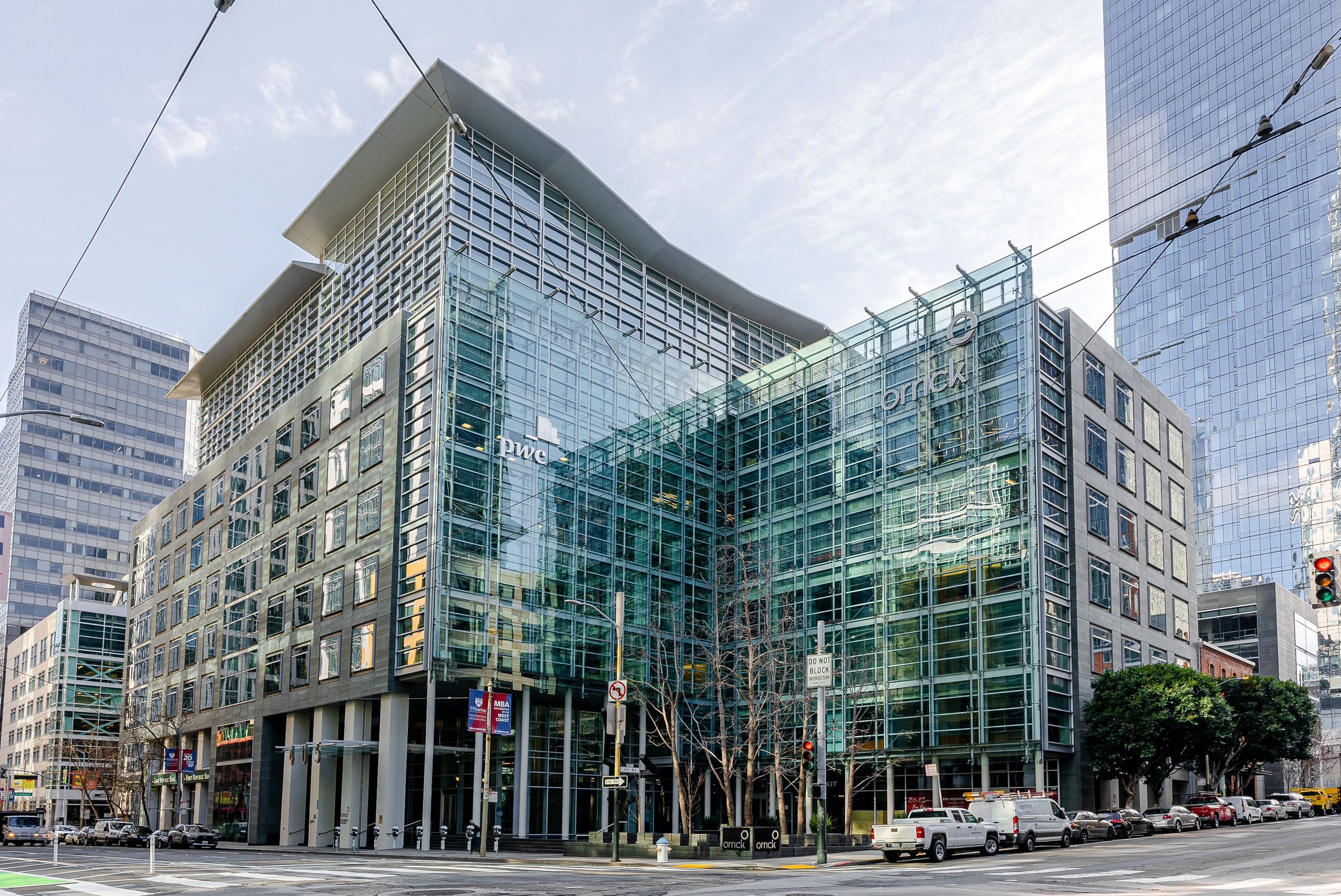 Exterior view of a modern glass office building in an urban setting.