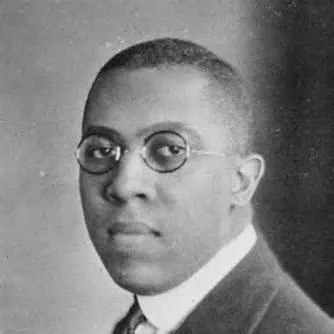 Historic black‑and‑white portrait of a person wearing a suit and tie.