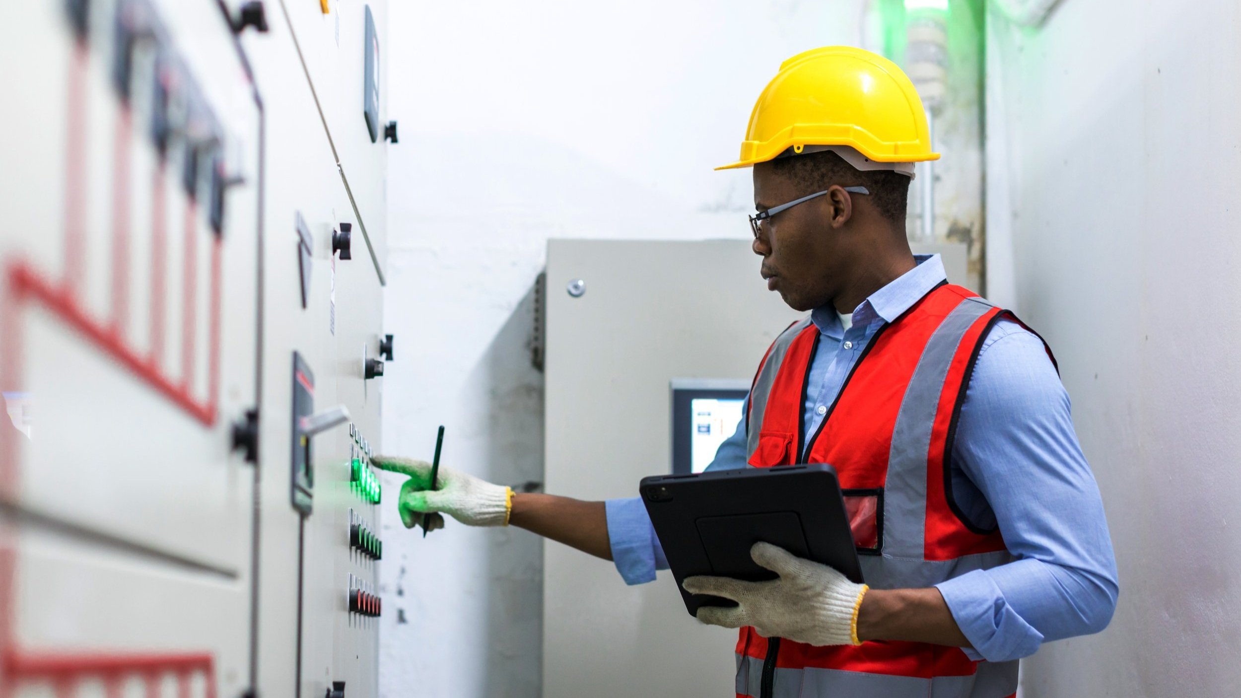 A person wearing safety gear pressing a button.
