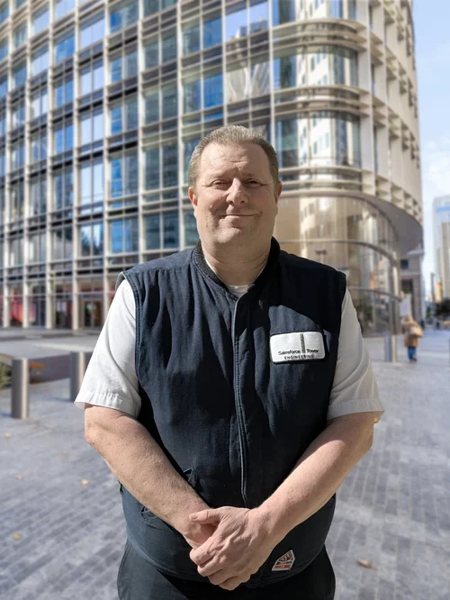  A person smiling in front of a building.&nbsp; 