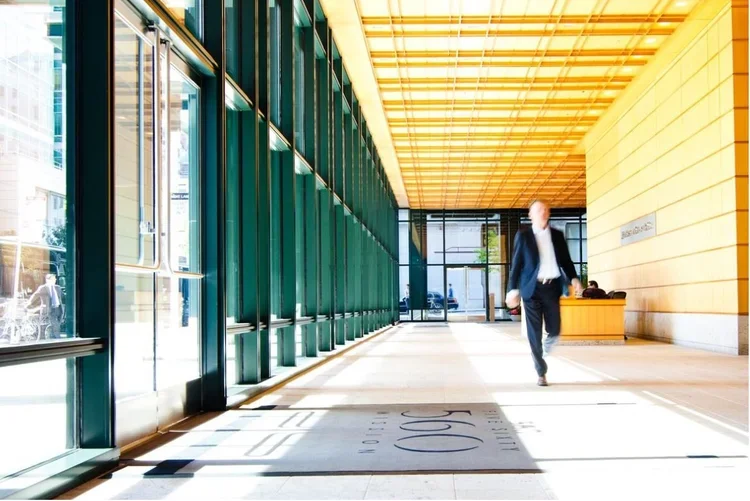Photo of the lobby at a light-filled office building. The door mat reads "560"