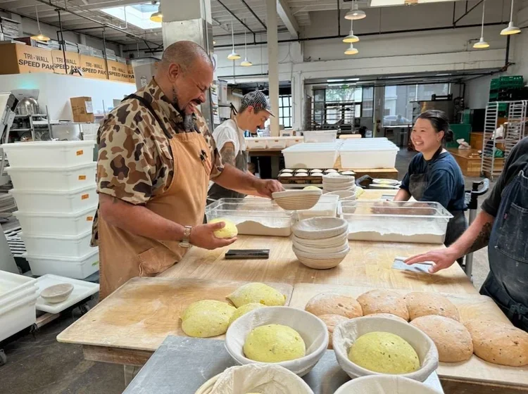 The bakery team smiles while working dough