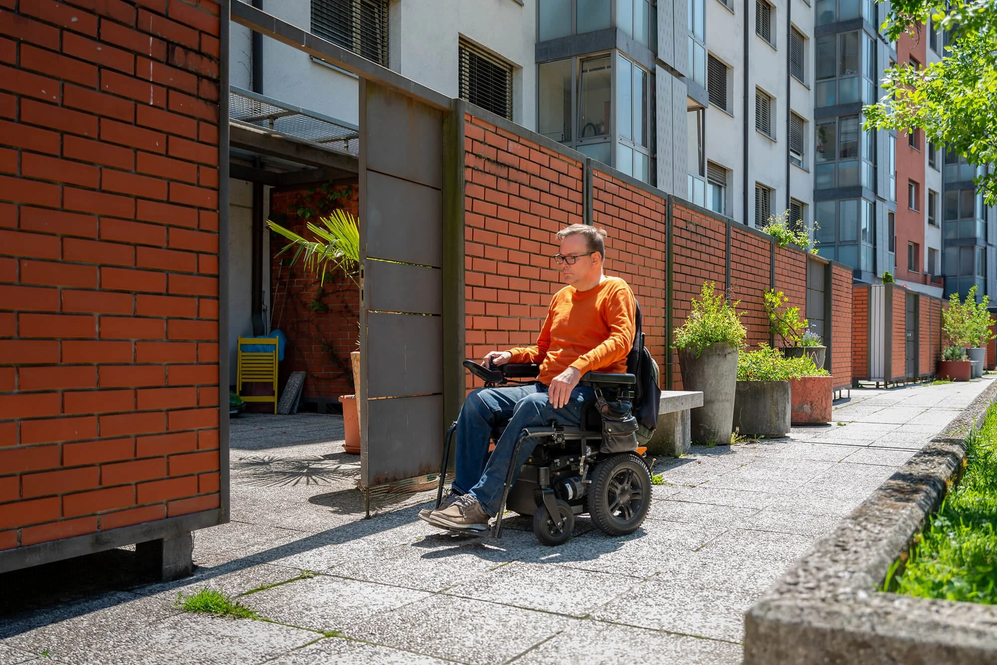 A person on a wheelchair outside a building.
