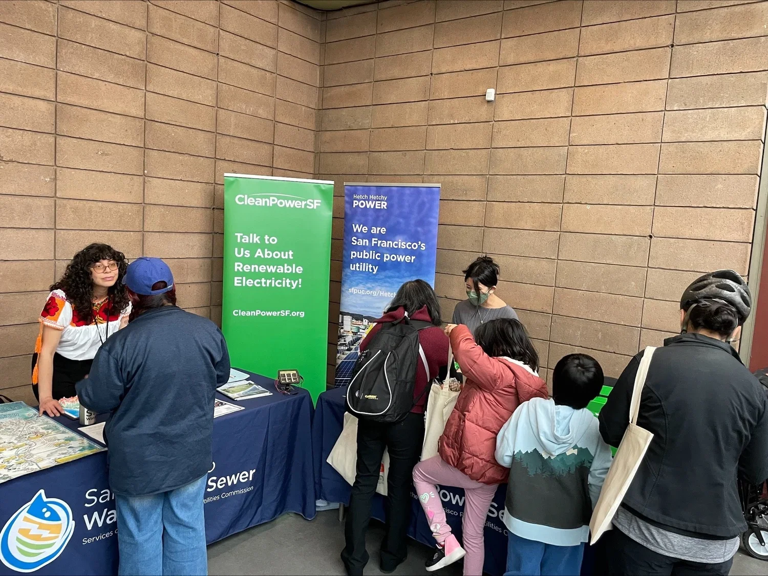People gather at the CleanPowerSF booth