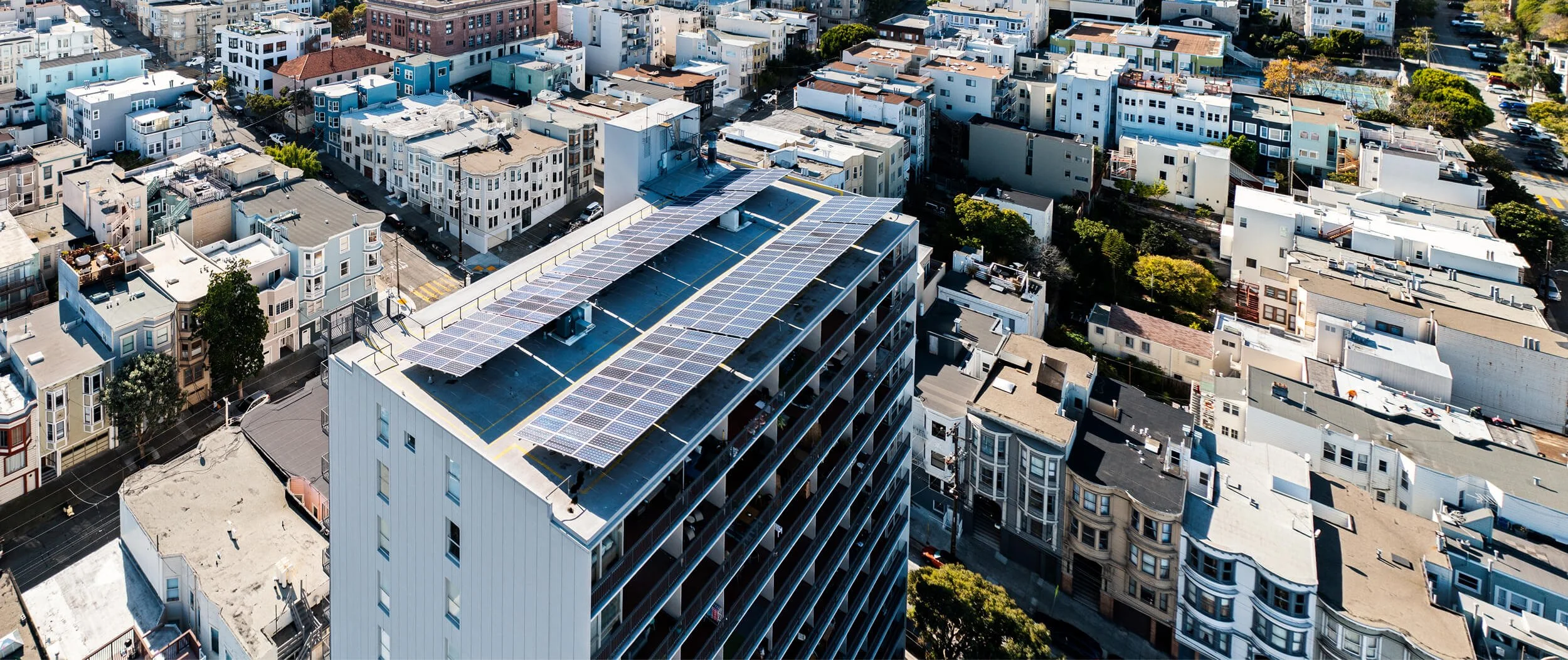 Aerial view of a solar panel installation on a building’s rooftop.