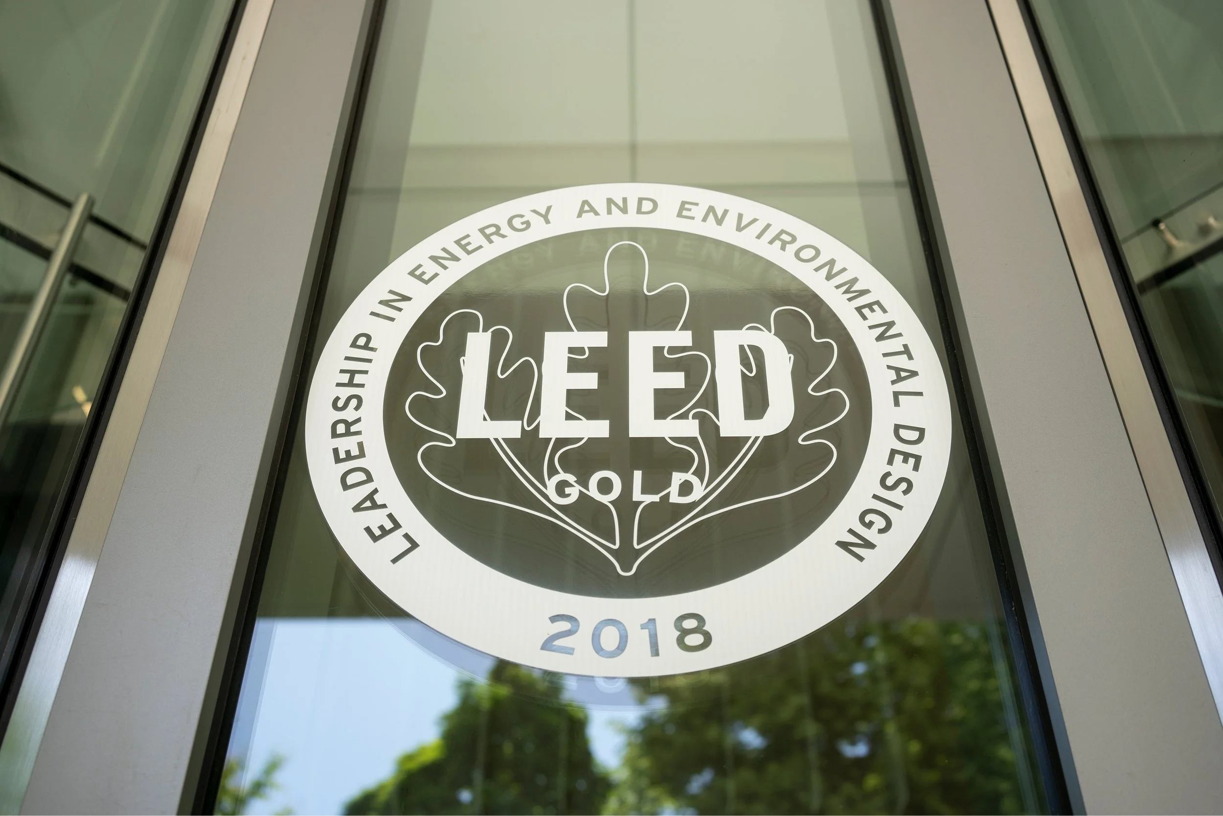 LEED symbol on a glass window that states, “ Leadership in Energy and Environmental Design.”