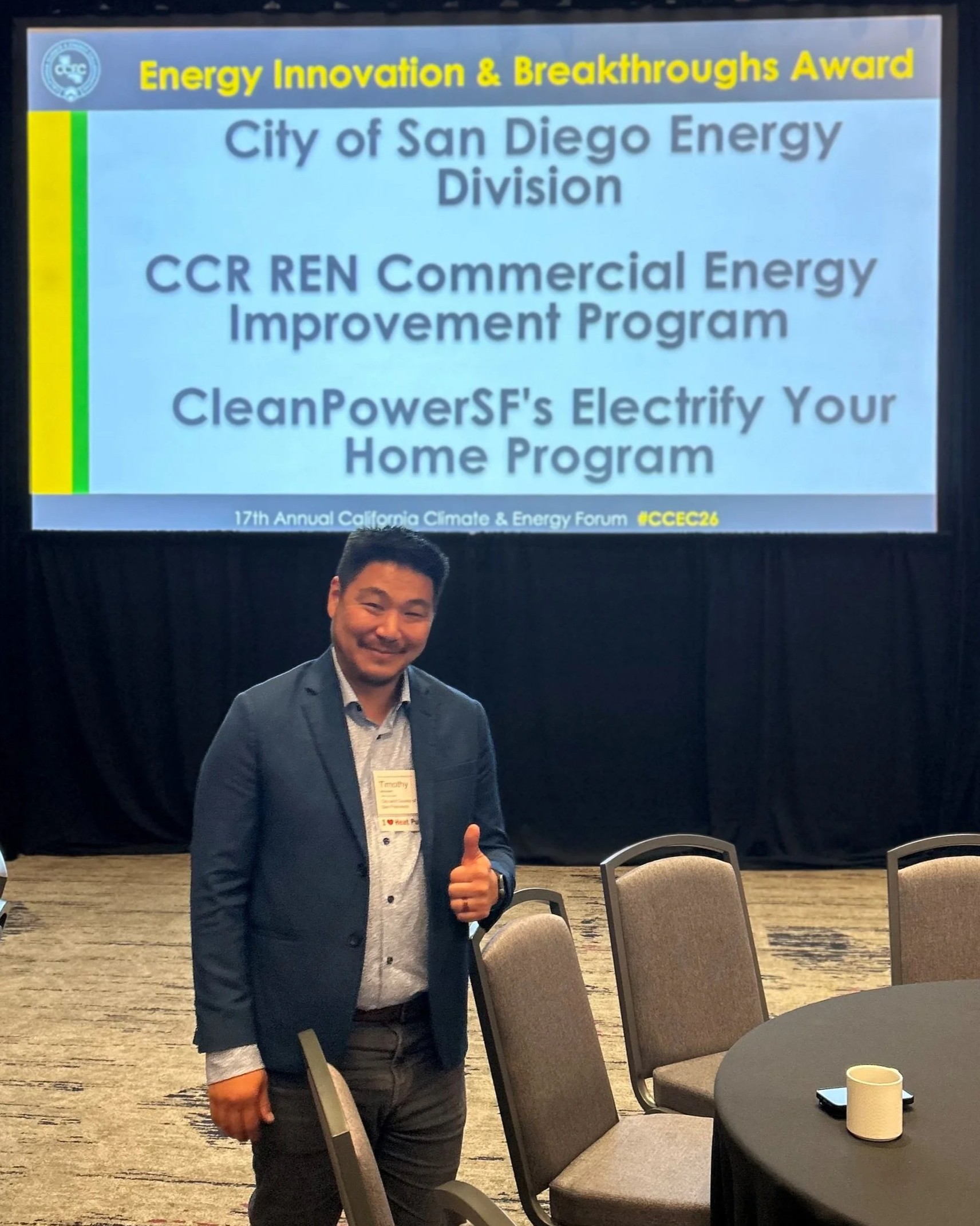 Tim Minezaki stands in front of the Energy Innovation & Breakthroughs Award Announcement at the forum.