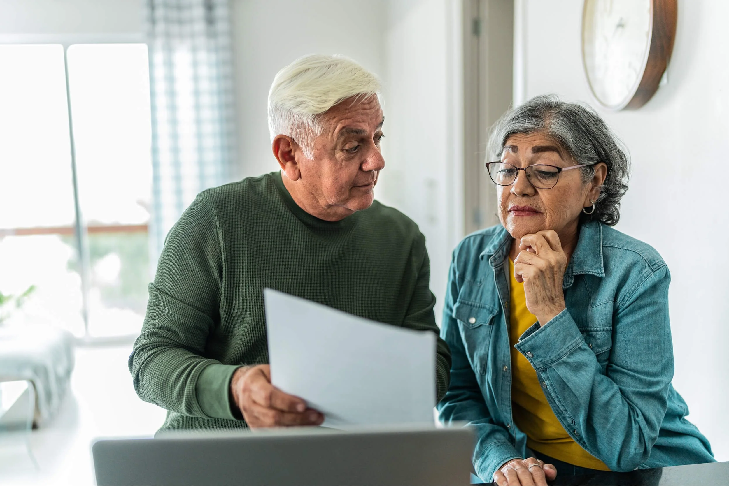 An elderly couple looking at their bill.