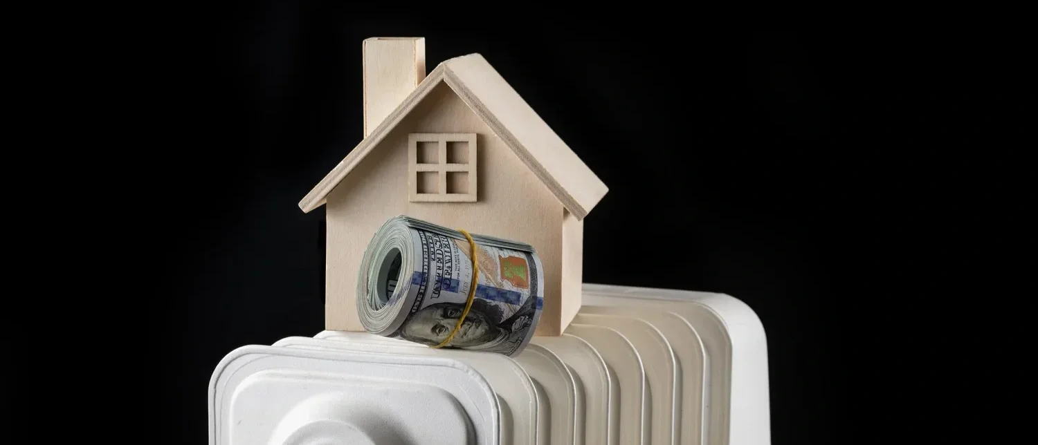 Model house and cash roll on a radiator.