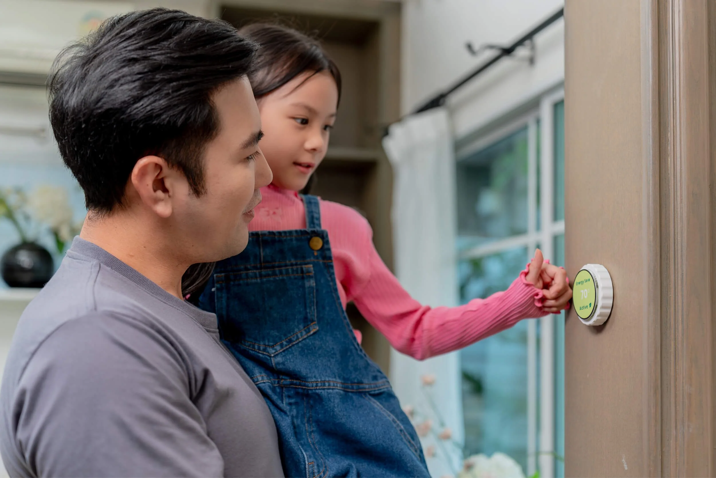 A parent and their child using a thermostat.