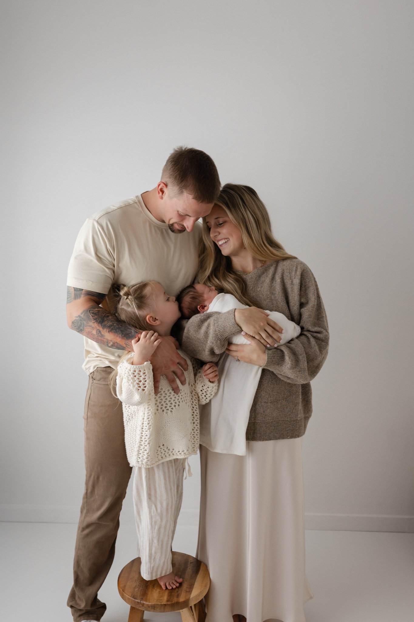Family posing with their newborn baby in Houston newborn studio with Houston newborn photographer