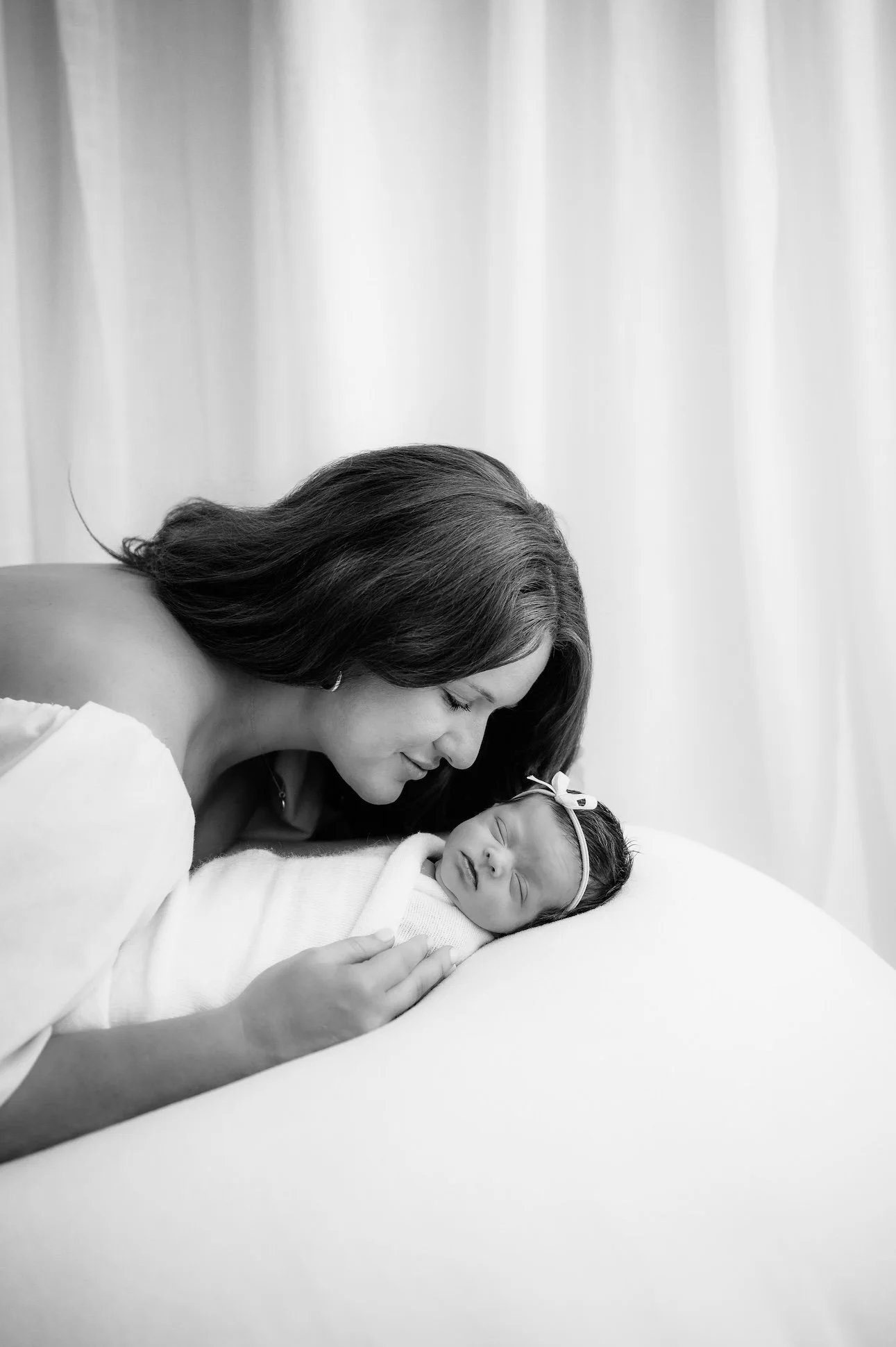 mom and newborn baby snuggle together for a newborn photography session in houston, texas